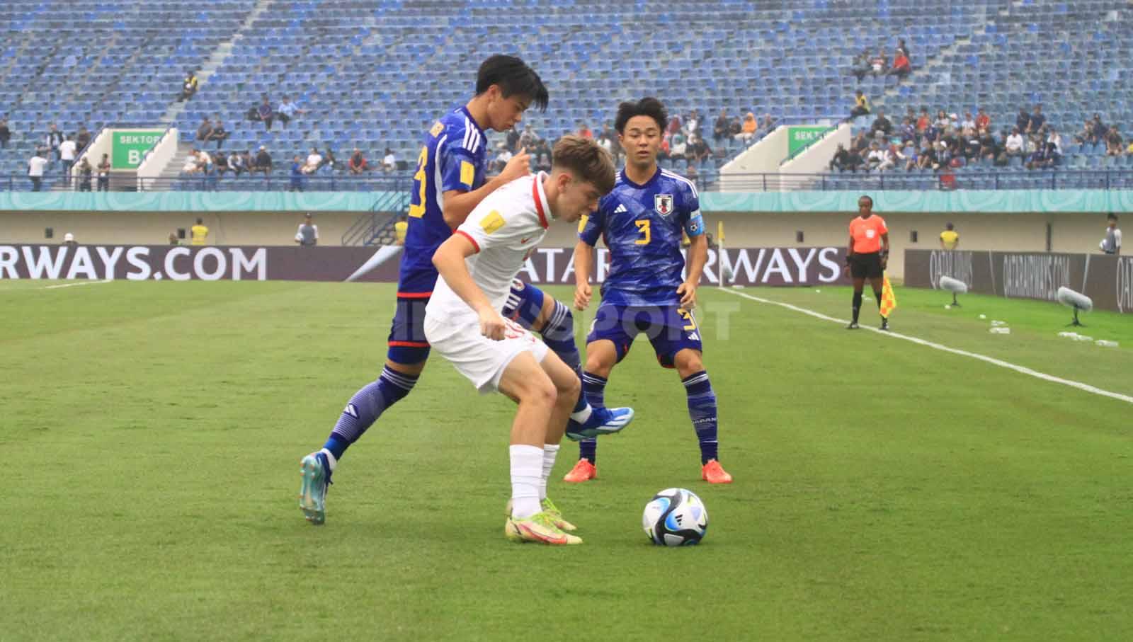 Gelandang Timans Polandia U-17, Lyczko Szymon, mendapat kawalan ketat dari pemain Jepang U-17, pada laga perdana Grup D Piala Dunia U-17 2023 di Stadion Si Jalak Harupat, Kabupaten Bandung, Sabtu (11/11/23). Arif Rahman/INDOSPORT