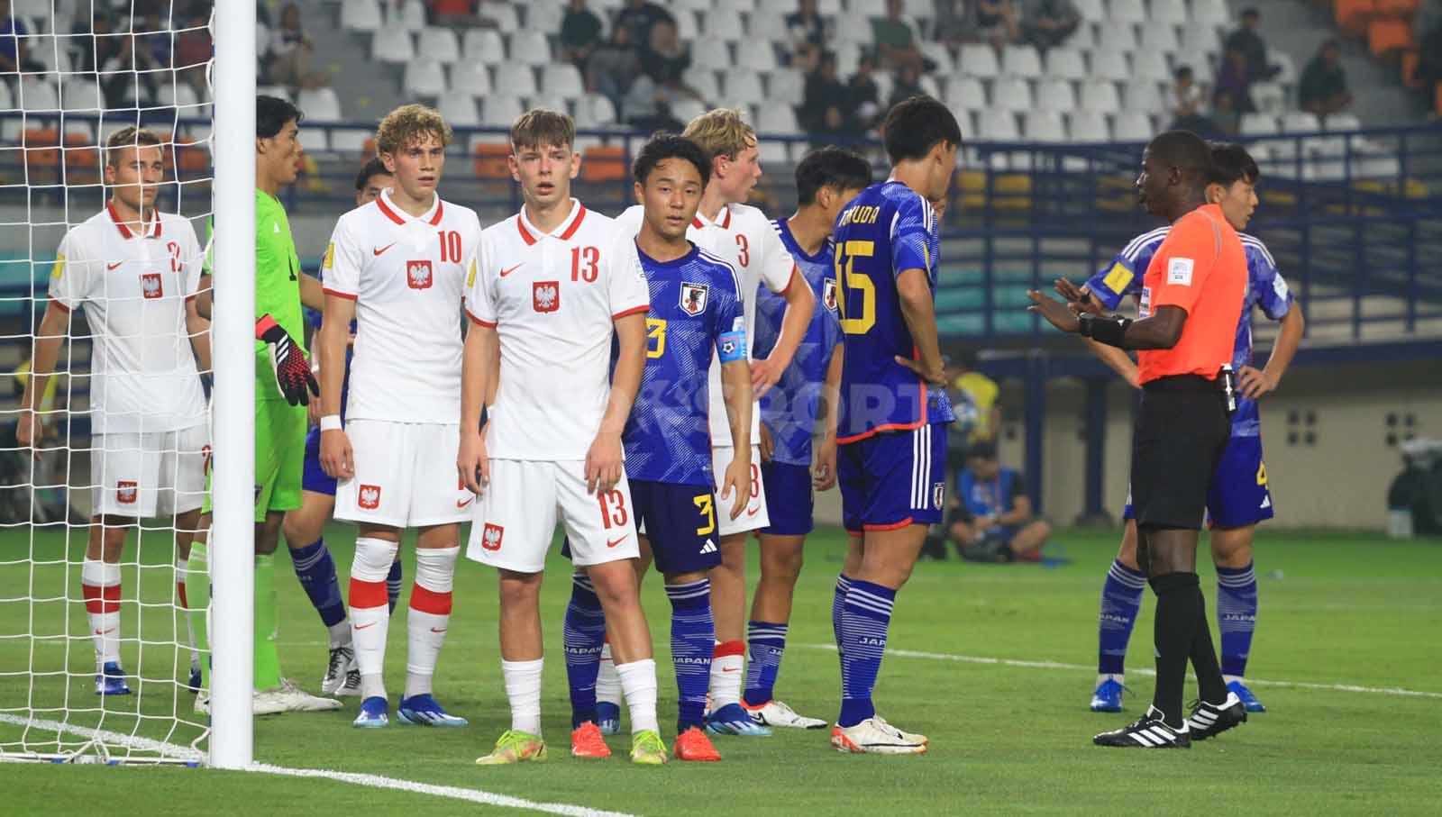 Kapten Timnas Jepang U-17, Kosugi Keita mengawal ketat gelandang Polandia U-17, Lyczko Szymon, pada laga perdana Grup D Piala Dunia U-17 2023 di Stadion Si Jalak Harupat, Kabupaten Bandung, Sabtu (11/11/23). Arif Rahman/INDOSPORT