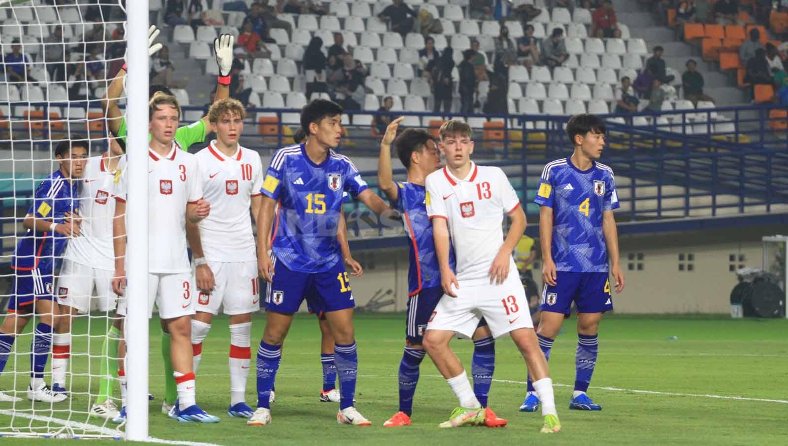 Gelandang Timans Polandia U-17, Lyczko Szymon, mencoba melepaskan kawalan dari pemain Jepang U-17, Kosugi Keita, pada laga perdana Grup D Piala Dunia U-17 2023 di Stadion Si Jalak Harupat, Kabupaten Bandung, Sabtu (11/11/23). Arif Rahman/INDOSPORT