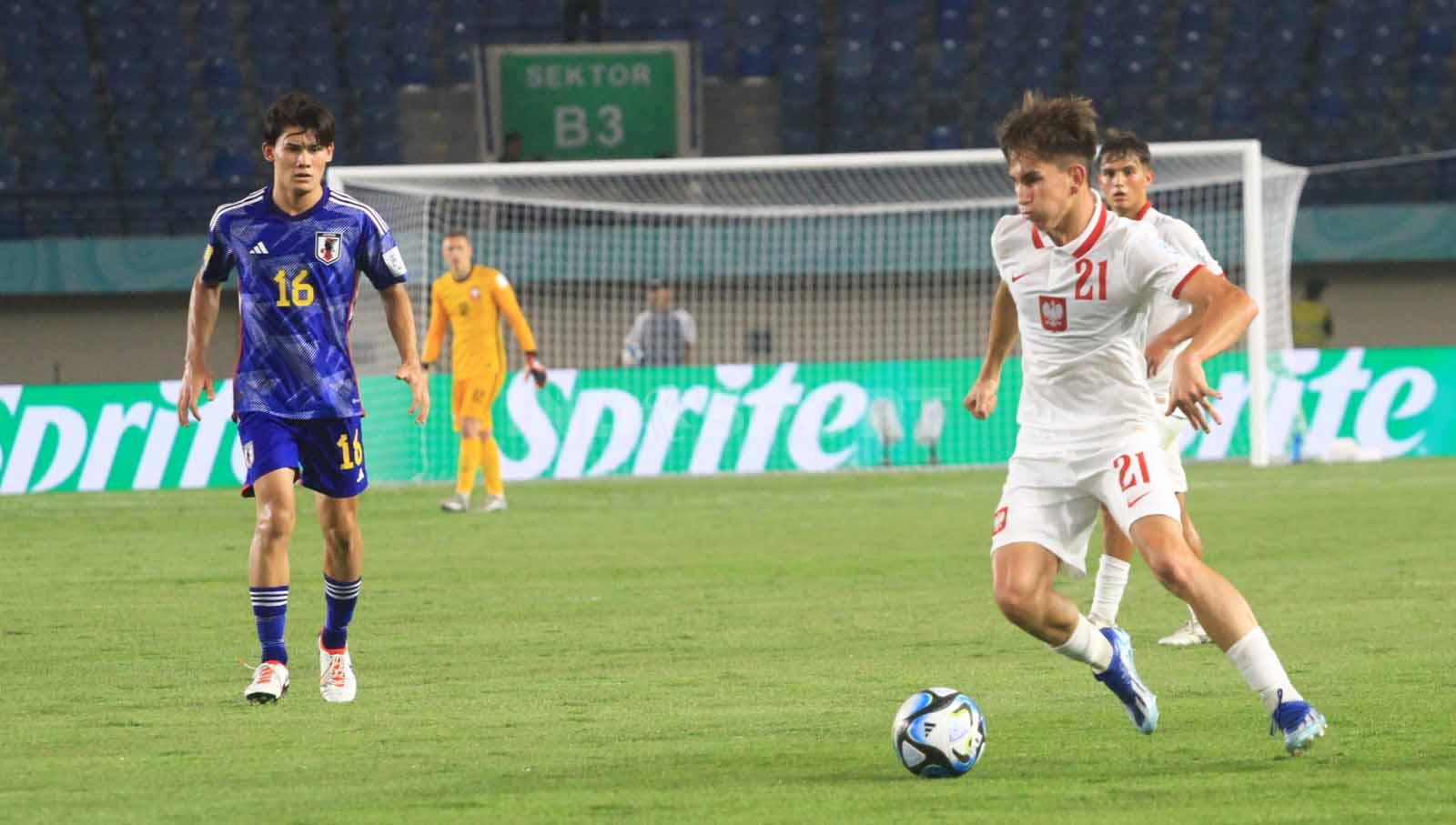 Pemain Timnas Polandia U-17, Regula Marcel mendapat pengawalan ketat dari pemain Jepang U-17, pada laga perdana Grup D Piala Dunia U-17 2023 di Stadion Si Jalak Harupat, Kabupaten Bandung, Sabtu (11/11/23). Arif Rahman/INDOSPORT
