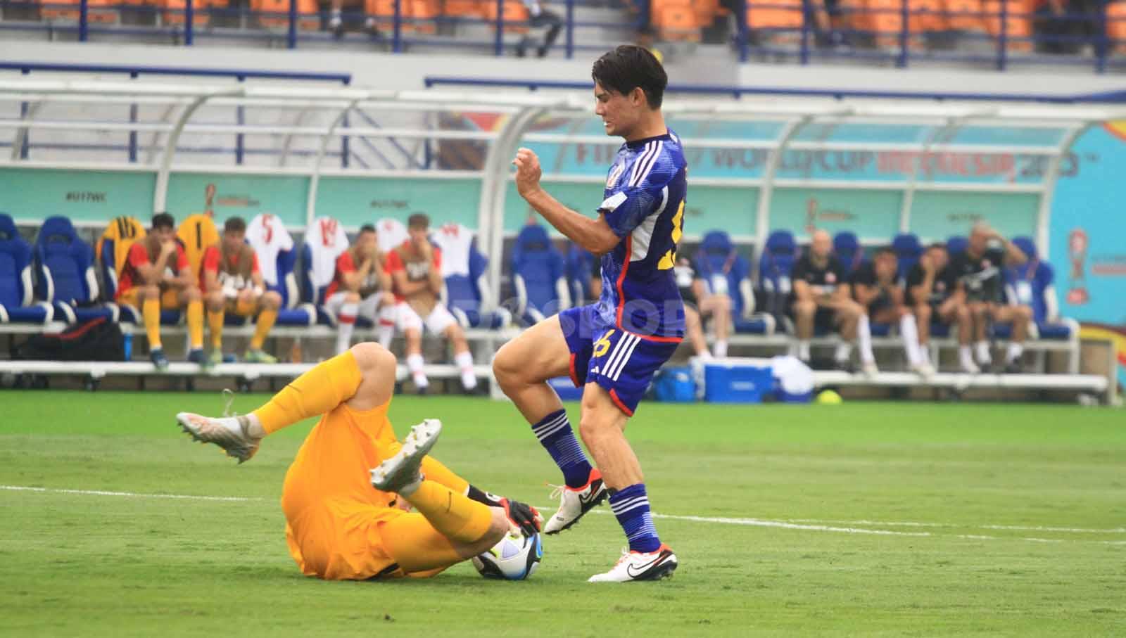 Striker Timans Jepang, Inoue menghindari benturan dengan penjaga gawang Polandia U-17, Matys Michal, pada laga perdana Grup D Piala Dunia U-17 2023 di Stadion Si Jalak Harupat, Kabupaten Bandung, Sabtu (11/11/23). Arif Rahman/INDOSPORT