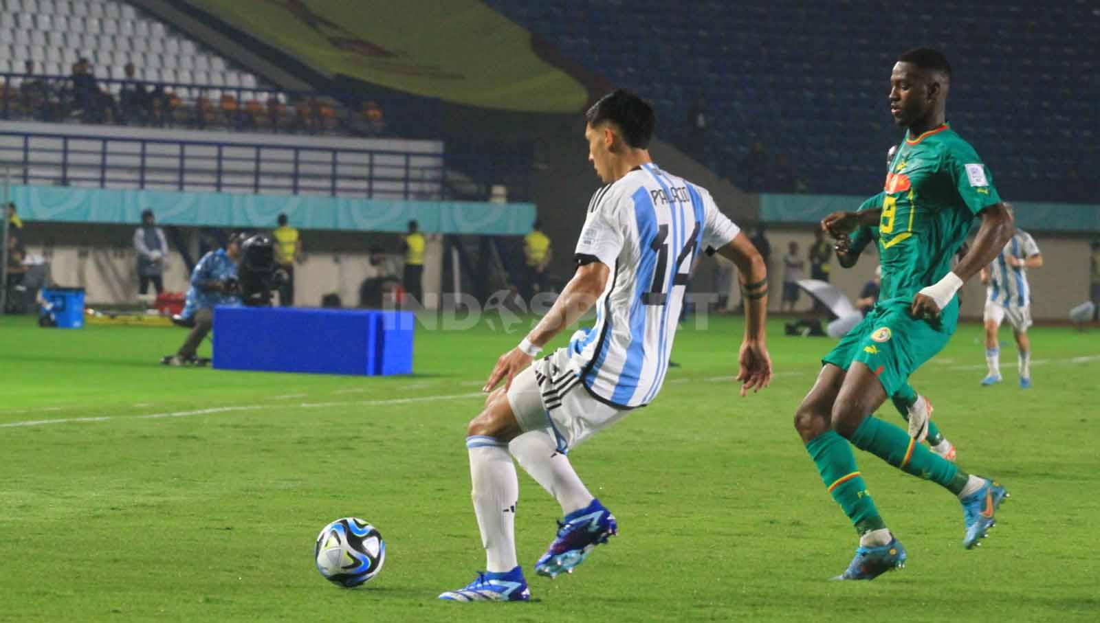 Bek Argentina U-17 Palacio Tobias dibayangi striker  Senegal U-17, Sall Omar  pada pertandingan Grup D Piala Dunia U-17 2023 di Stadion Si Jalak Harupat, Kabupaten Bandung, Sabtu (11/11/23). Arif Rahman/INDOSPORT
