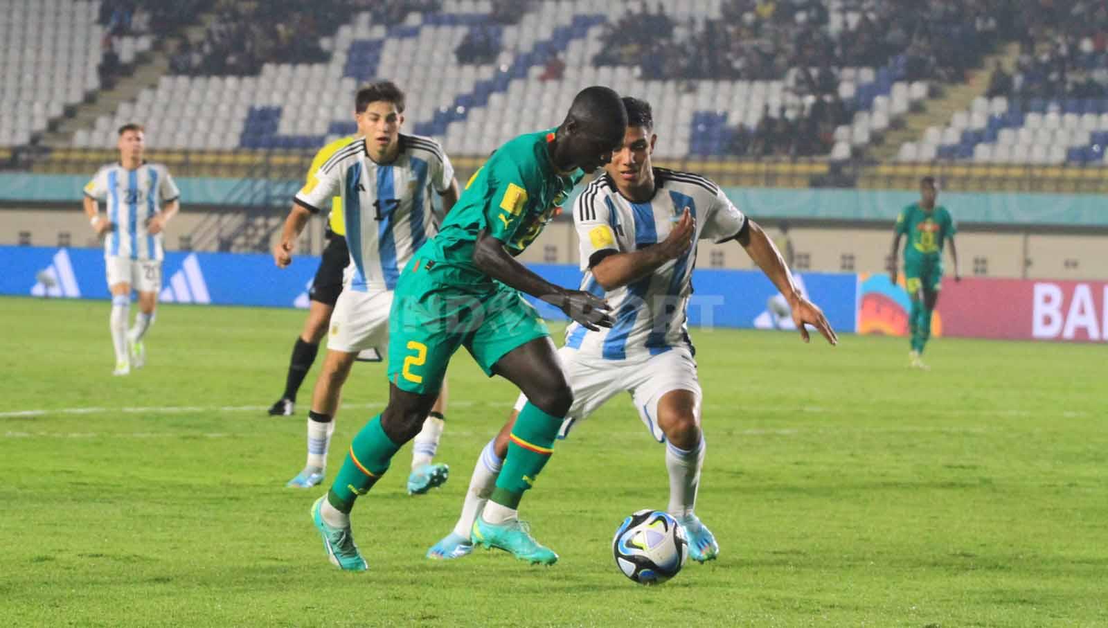 Striker Senegal U-17, Diandy Clayton, melewati pemain Argentina U-17, pada pertandingan Grup D Piala Dunia U-17 2023 di Stadion Si Jalak Harupat, Kabupaten Bandung, Sabtu (11/11/23). Arif Rahman/INDOSPORT