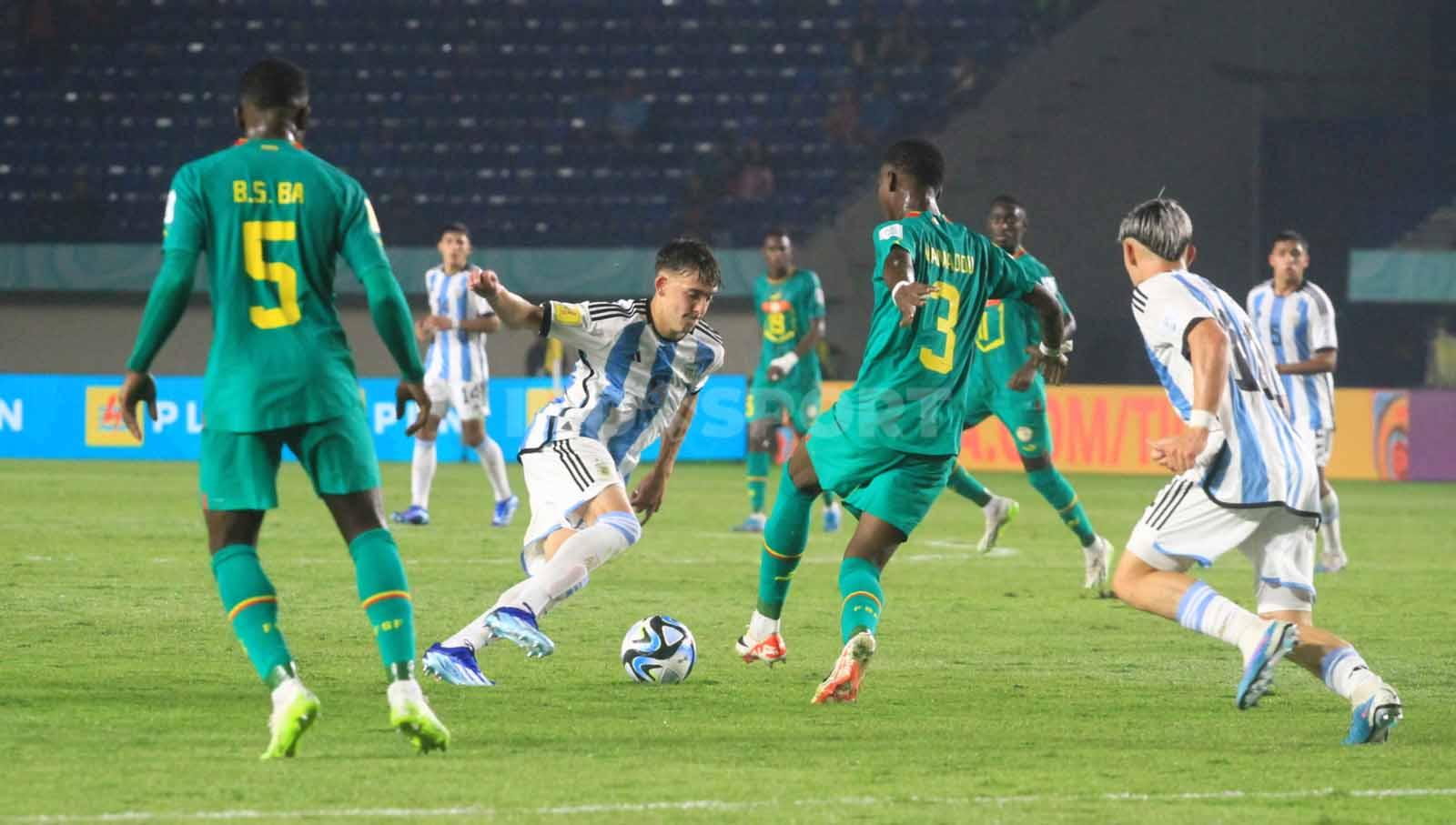 Gelandang Argentina U-17, Albbaracin Gustavo mendapatkan pengawalan ketat dari pemain Senegal U-17, pada pertandingan Grup D Piala Dunia U-17 2023 di Stadion Si Jalak Harupat, Kabupaten Bandung, Sabtu (11/11/23). Arif Rahman/INDOSPORT