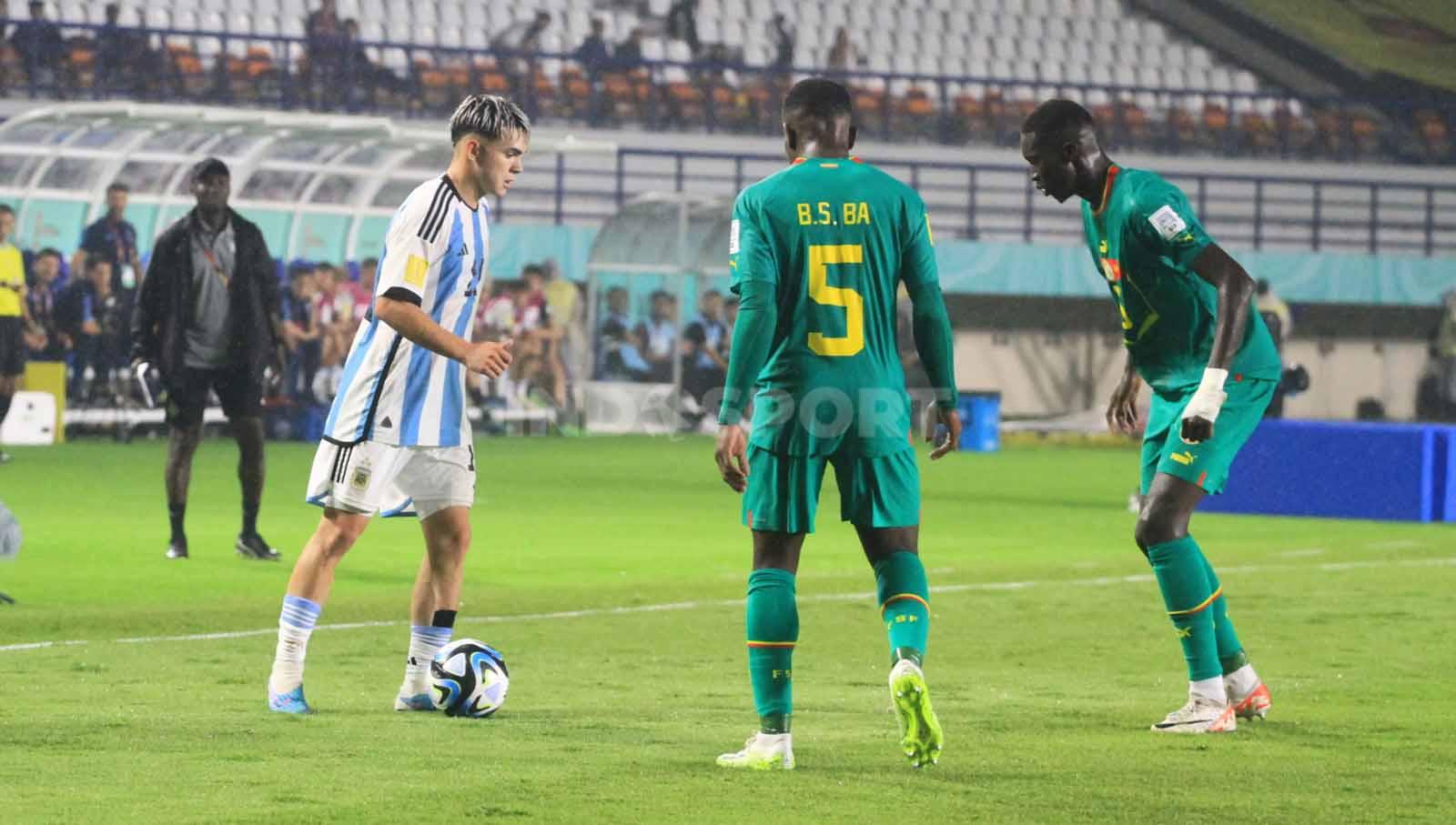 Stiker Argentina U-17, Lopez Santiago mendapatkan pengawalan ketat dari pemain Senegal U-17, pada pertandingan Grup D Piala Dunia U-17 2023 di Stadion Si Jalak Harupat, Kabupaten Bandung, Sabtu (11/11/23). Arif Rahman/INDOSPORT