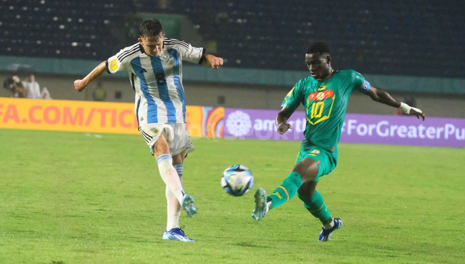 Gelandang Argentina U-17, Albbaracin Gustavo mendapatkan pengawalan ketat dari pemain Senegal U-17, Diouf Amara pada pertandingan Grup D Piala Dunia U-17 2023 di Stadion Si Jalak Harupat, Kabupaten Bandung, Sabtu (11/11/23). Arif Rahman/INDOSPORT