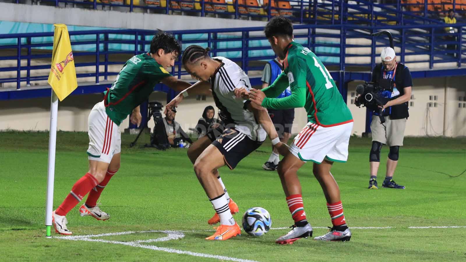 Pemain Jerman U-17, Da Silava Moreira Eric, dikawal ketat bek Meksiko U-17 pada pertandingan Grup F Piala Dunia U-17 2023 di Stadion Si Jalak Harupat, Kabupaten Bandung, Minggu (12/11/23). (Foto: Arif Rahman/INDOSPORT)