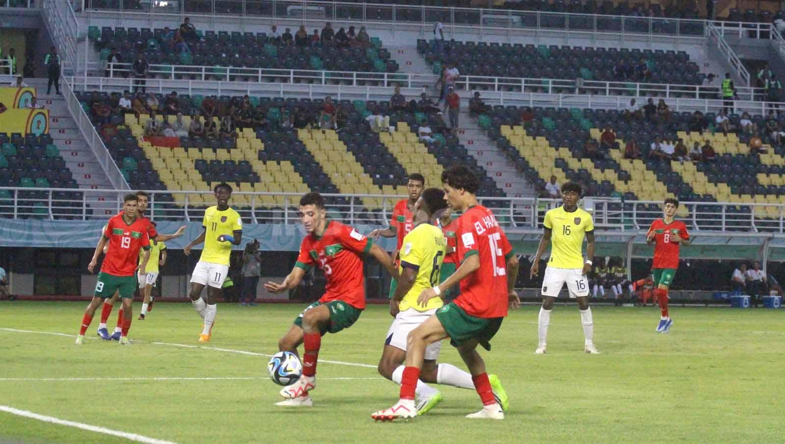 Pemain Ekuador U-17 Elkin Ruiz ditekel dua pemain Maroko yang menyebabkan penalti pada laga Piala Dunia U-17. (Foto: Fitra Herdian/INDOSPORT)