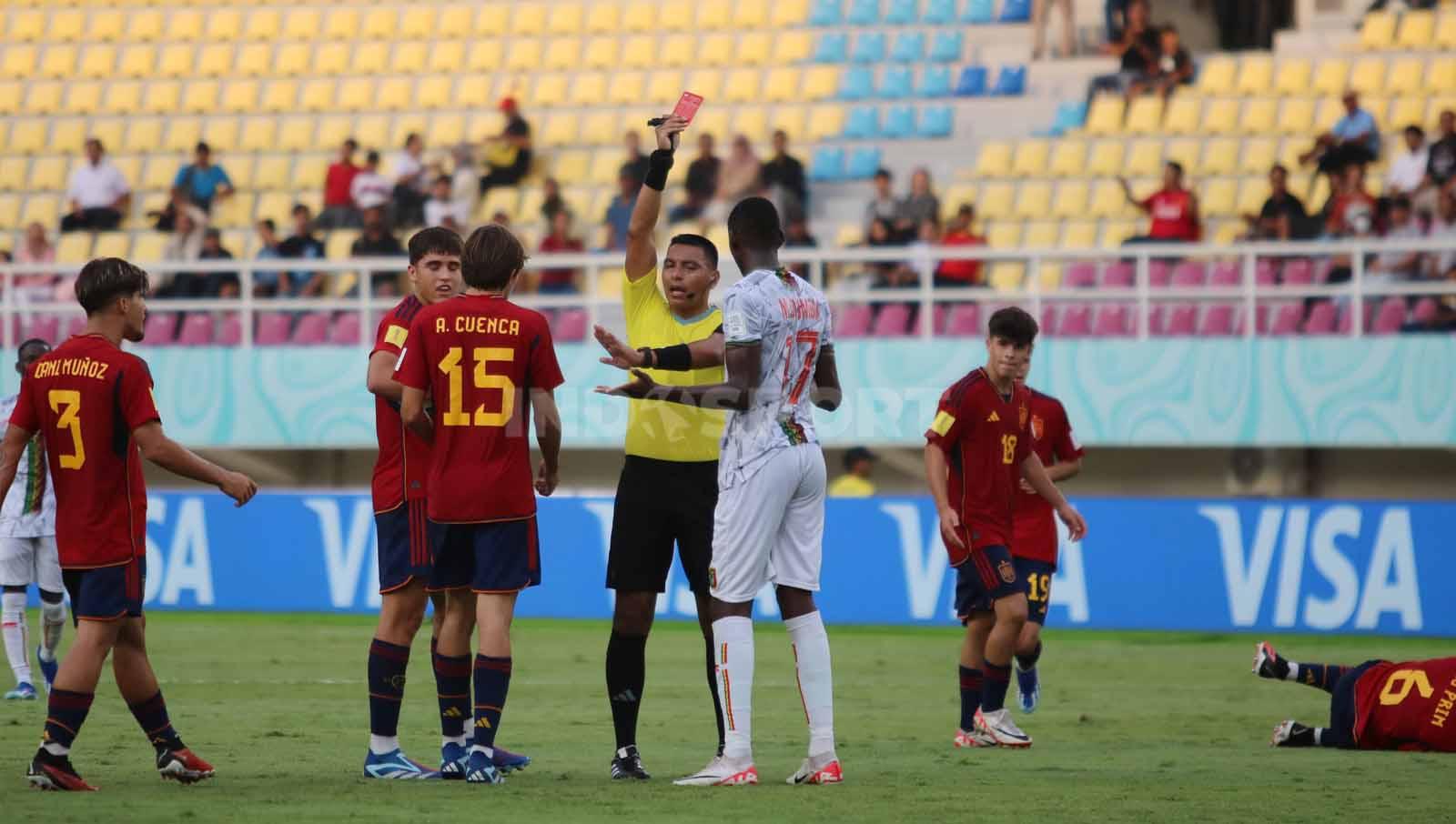 Wasit Guatemala, Bryan Lopez, memberikan kartu merah kepada Mamadou Doumbia dalam pertandingan Piala Dunia U-17 2023 grup B di Stadion Manahan Solo, Senin (13/11/23). (Foto: Nofik Lukman Hakim/INDOSPORT)