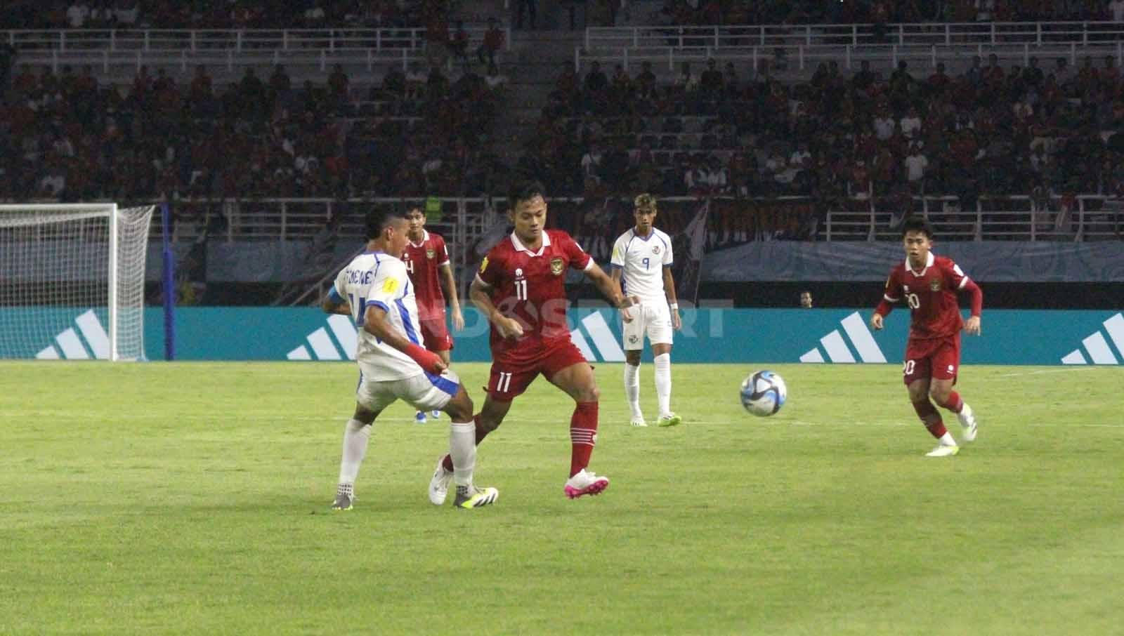 Pemain Indonesia U-17 Riski Afrisal diadang pemain Panama Juan Jimenez pada laga Piala Dunia U-17 di Stadion Gelora Bung Tomo, Senin (13/11/23). (Foto: Fitra Herdian/INDOSPORT)