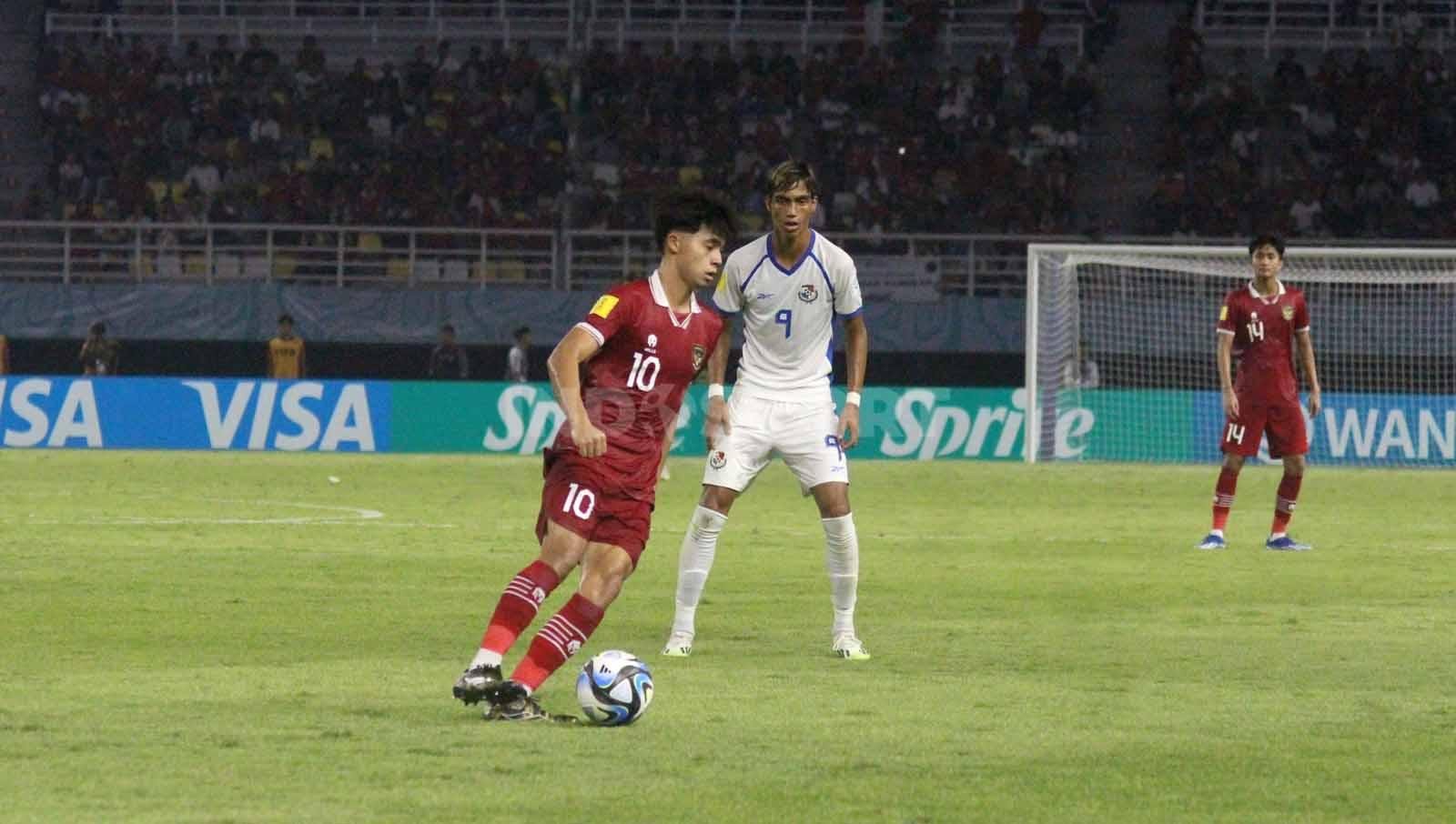 Pemain Indonesia U-17 Ji Da Bin mempertahankan bola dari Frederick Krug pada laga Piala Dunia U-17 di Stadion Gelora Bung Tomo, Senin (13/11/23). (Foto: Fitra Herdian/INDOSPORT)