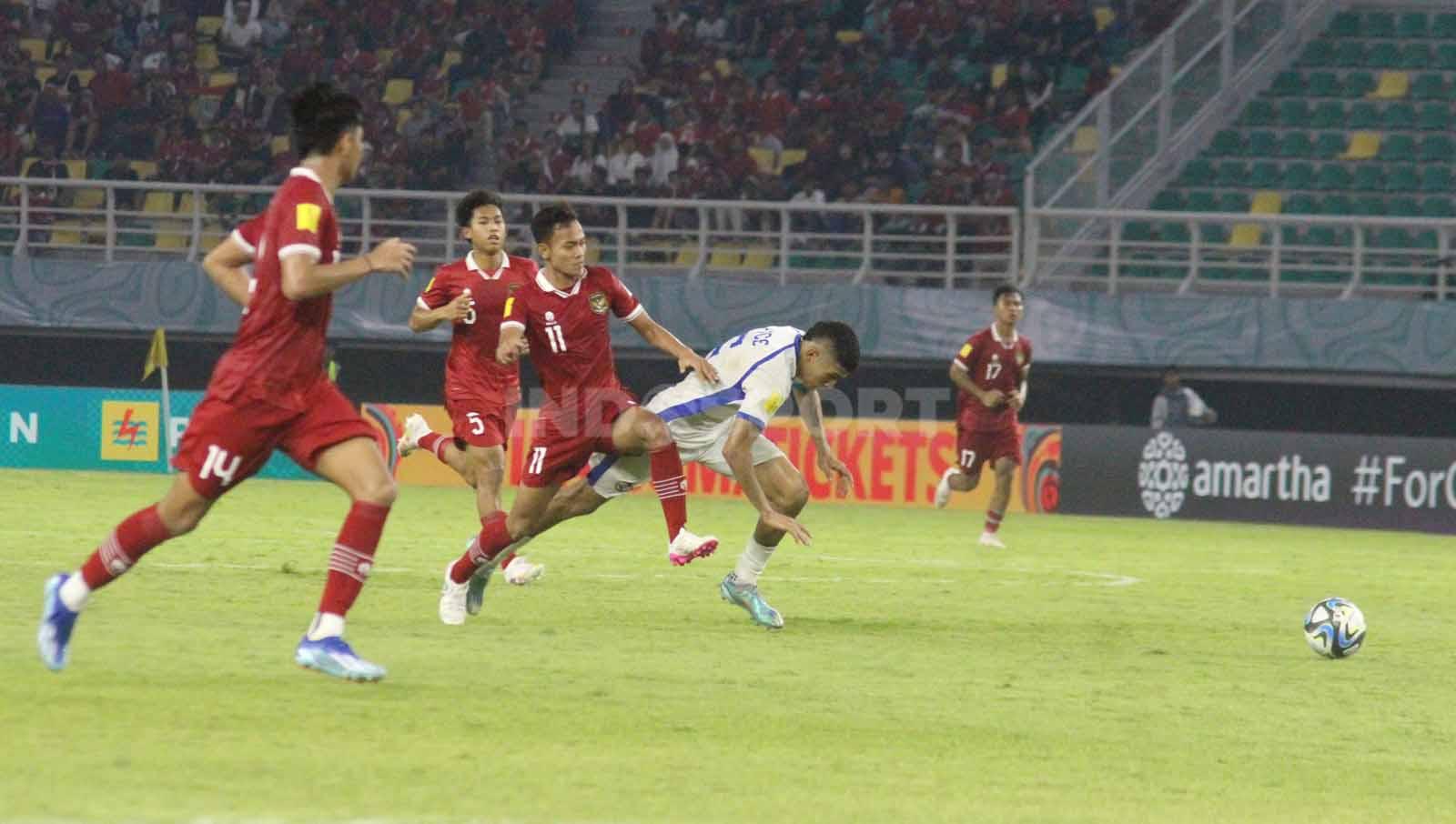 Riski Afrisal berusaha mengadang pemain Panama U-17 yang hendak mencetak gol pada laga Piala Dunia U-17 di Stadion Gelora Bung Tomo, Senin (13/11/23). (Foto: Fitra Herdian/INDOSPORT)