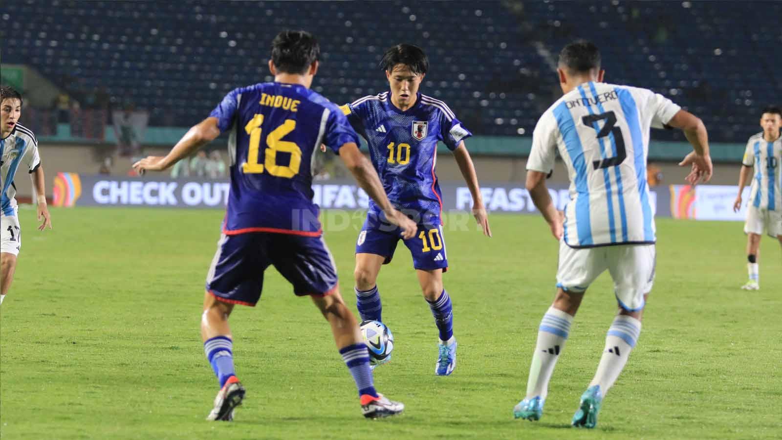 Gelandang Timnas Jepang U-17, Ryunosuke Sato, nampak dihadang dua pemain Timnas Argentina U-17.