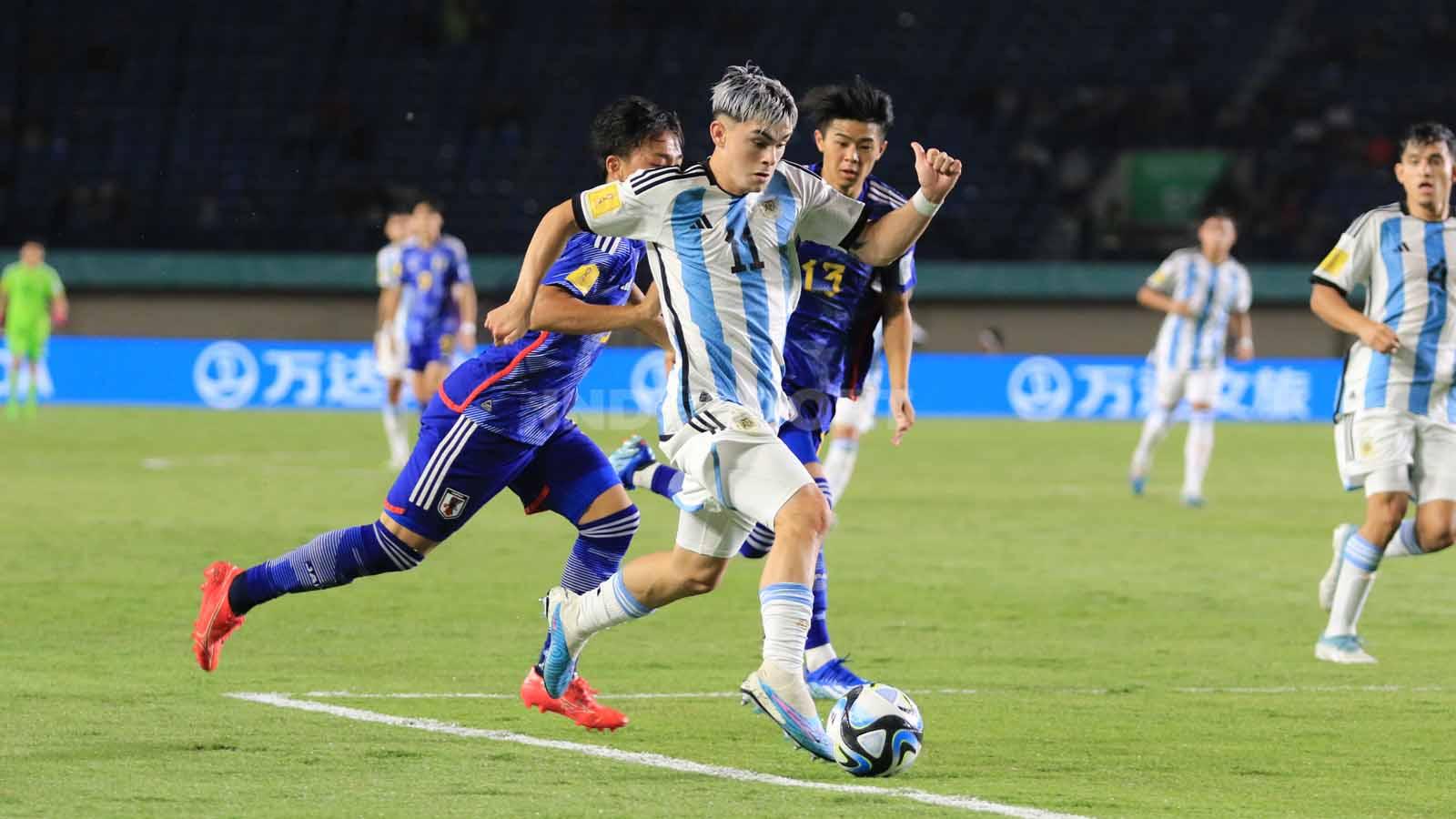 Gelandang Timnas Argentina U-17, Santiago Lopes, melewati bek Timnas Jepang U-17, Keita Kosugi.