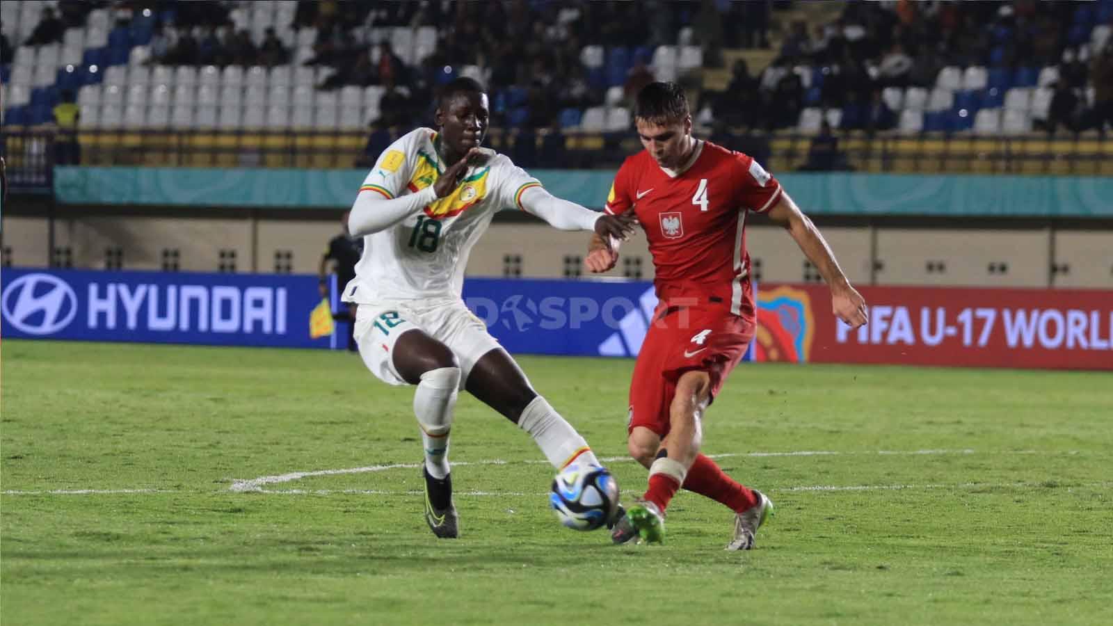 Bek Timnas Polandia U-17, Igor Orlikowski, berebut bola dengan striker Timnas Senegal U-17, Mamadou Sawane.