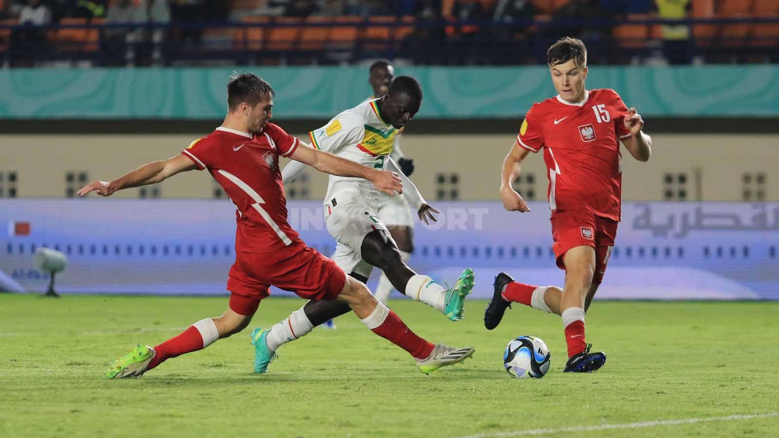 Striker Timnas Senegal U-17, Clayton Diandy, mendapat pengawalan ketat dari pemain Timnas Polandia U-17.
