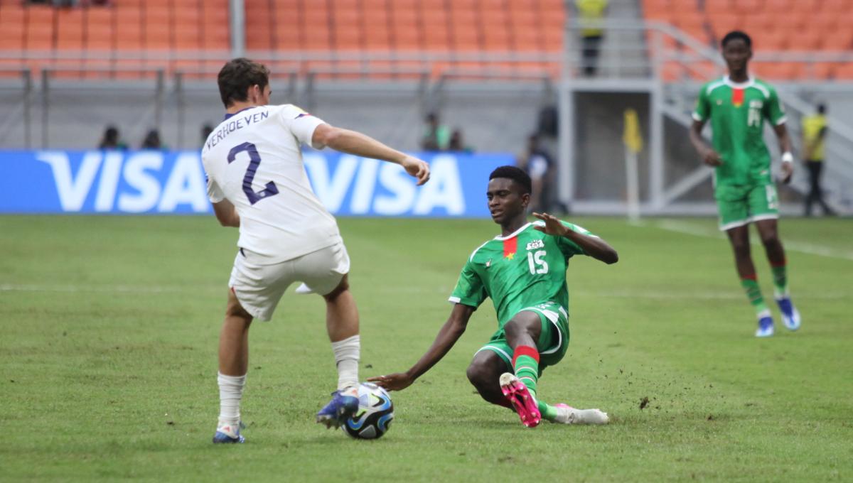 Pemain Burkina Faso, Idrissa Sore (kanan) melakukan tackle ke arah pemain Amerika Serikat, Oscar Verhoeven pada laga kedua fase grup E Piala Dunia U-17 2023 di Stadion JIS, Rabu (15/11/23).
