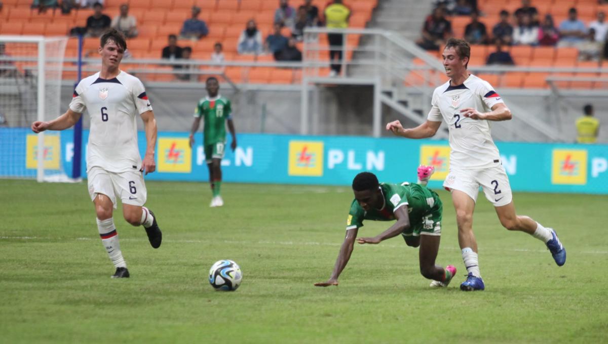 Pemain Burkina Faso dijatuhkan pemain Amerika Serikat, Oscar Verhoeven pada laga kedua fase grup E Piala Dunia U-17 2023 di Stadion JIS, Rabu (15/11/23).