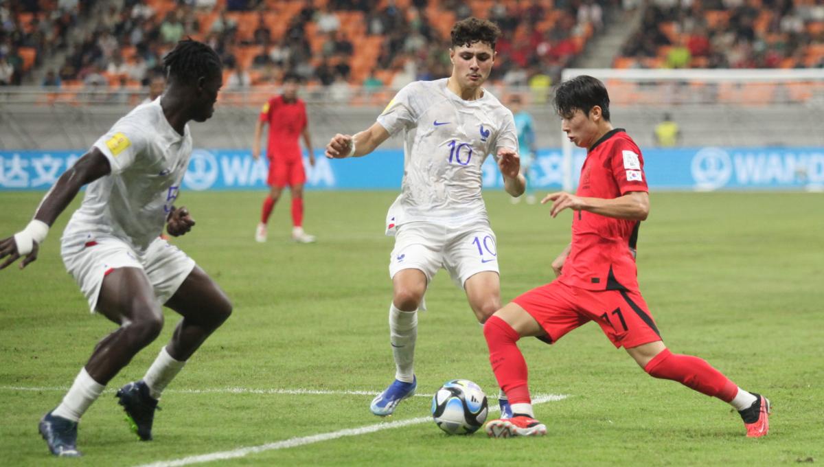 Pemain Korsel, M H Yang memcoba melewati hadangan dua pemain Prancis dalam laga kedua fase grup E Piala Dunia U-17 2023 di Stadion JIS, Rabu (15/11/23).