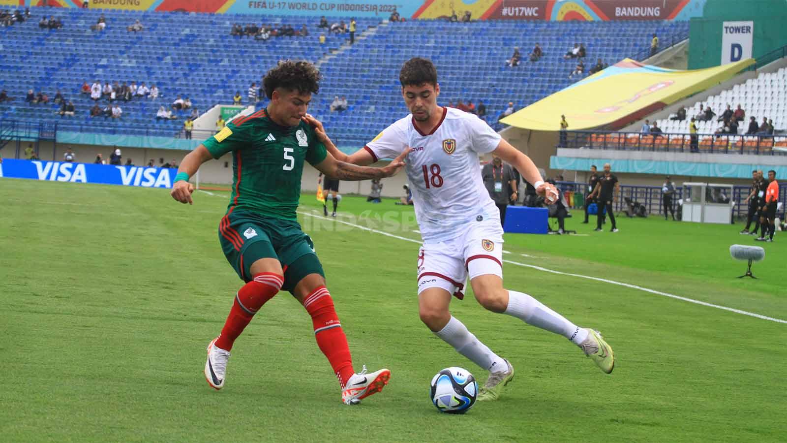 Stiker Venezuela U-17, Cichero Alejandro dikawal ketat oleh bek Mexico U-17, Romero Javen pada pertandingan Grup F Piala Dunia U-17 2023 di Stadion Gelora Bandung Lautan Api (GBLA), Kota Bandung, Rabu (15/11/23).