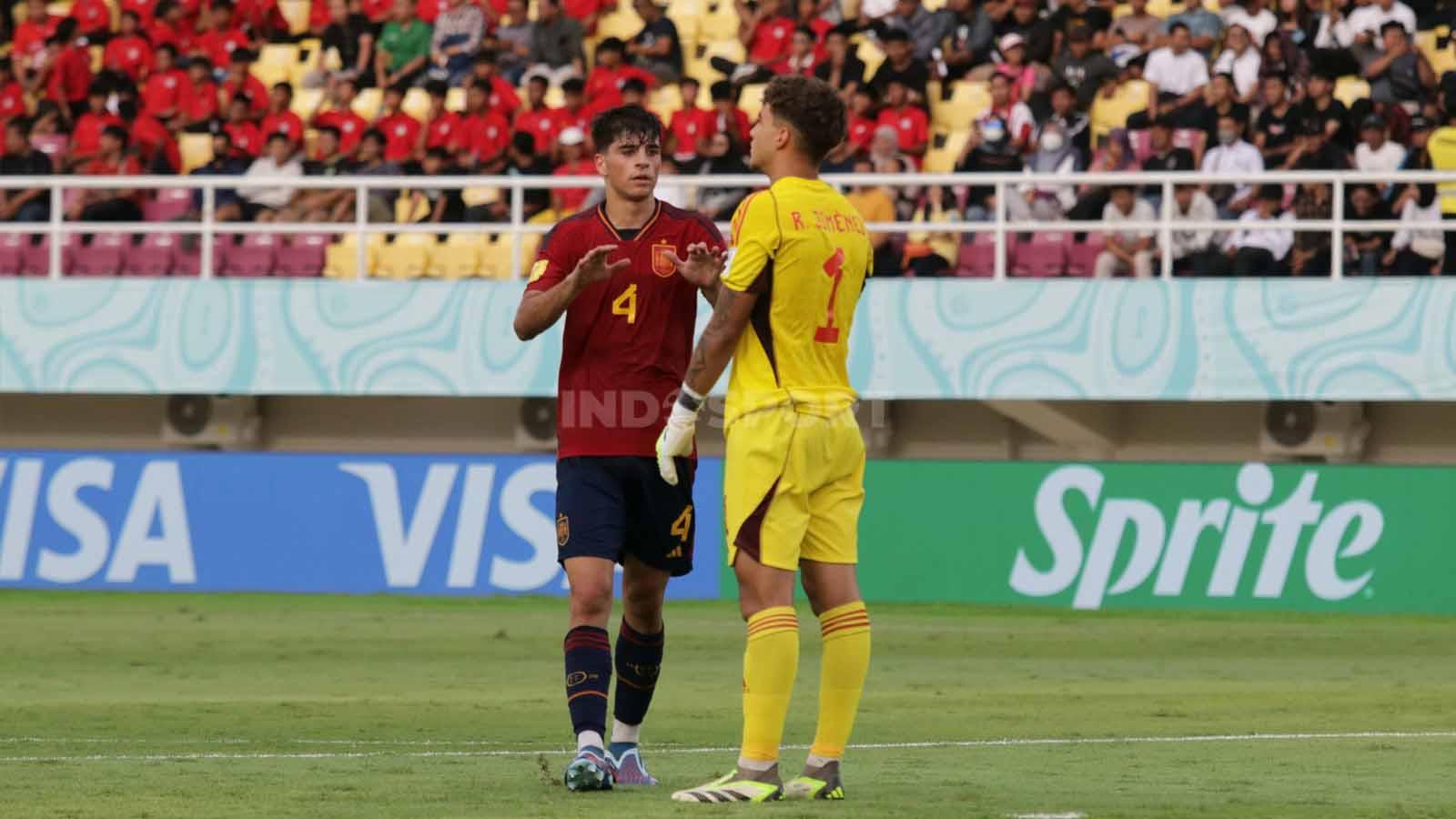 Bek Spanyol, Jon Martin, menenangkan sang kiper, Raul Jimenez, usai melakukan blunder yang berbuah gol untuk Uzbekistan  dalam pertandingan fase grup B Piala Dunia U-17 2023 di Stadion Manahan Solo, Kamis (16/11/23). (Foto: Nofik Lukman Hakim/INDOSPORT)