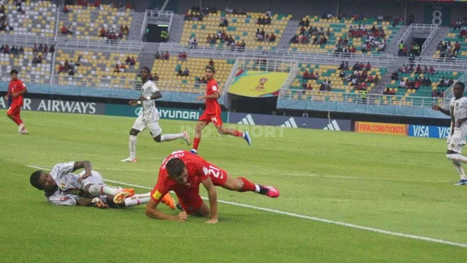 Pemain Kanada Lucas Ozimec jatuh bangun berebut bola dengan pemain Mali di pertandingan Grup B Piala Dunia U-17, Stadion Gelora Bung Tomo, Kamis (16/11/23). (Foto: Fitra Herdian/INDOSPORT)