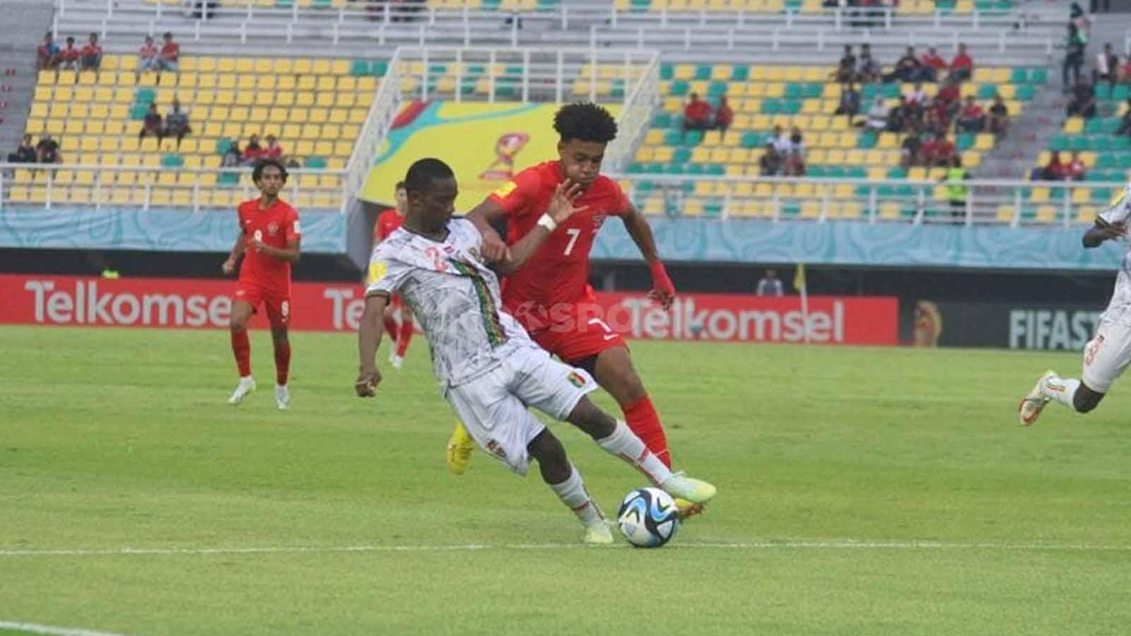Pemain Mali Moussa Traore ditempel ketat pergerakannya oleh pemain Kanada Taryck Tahid pada pertandingan Grup B Piala Dunia U-17 di Stadion Gelora Bung Tomo, Kamis (16/11/23). (Foto: Fitra Herdian/INDOSPORT)