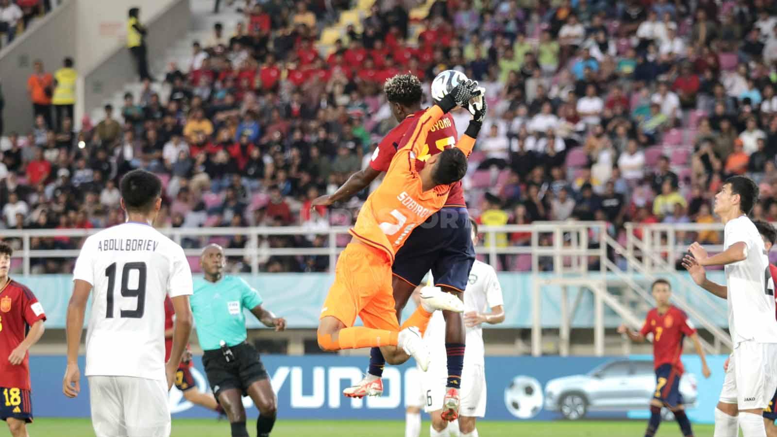 Kiper Uzbekistan, Muhammad Yusuf Sobirov, gagal menangkap bola saat duel udara  dalam pertandingan fase grup B Piala Dunia U-17 2023 di Stadion Manahan Solo, Kamis (16/11/23). (Foto: Nofik Lukman Hakim/INDOSPORT)