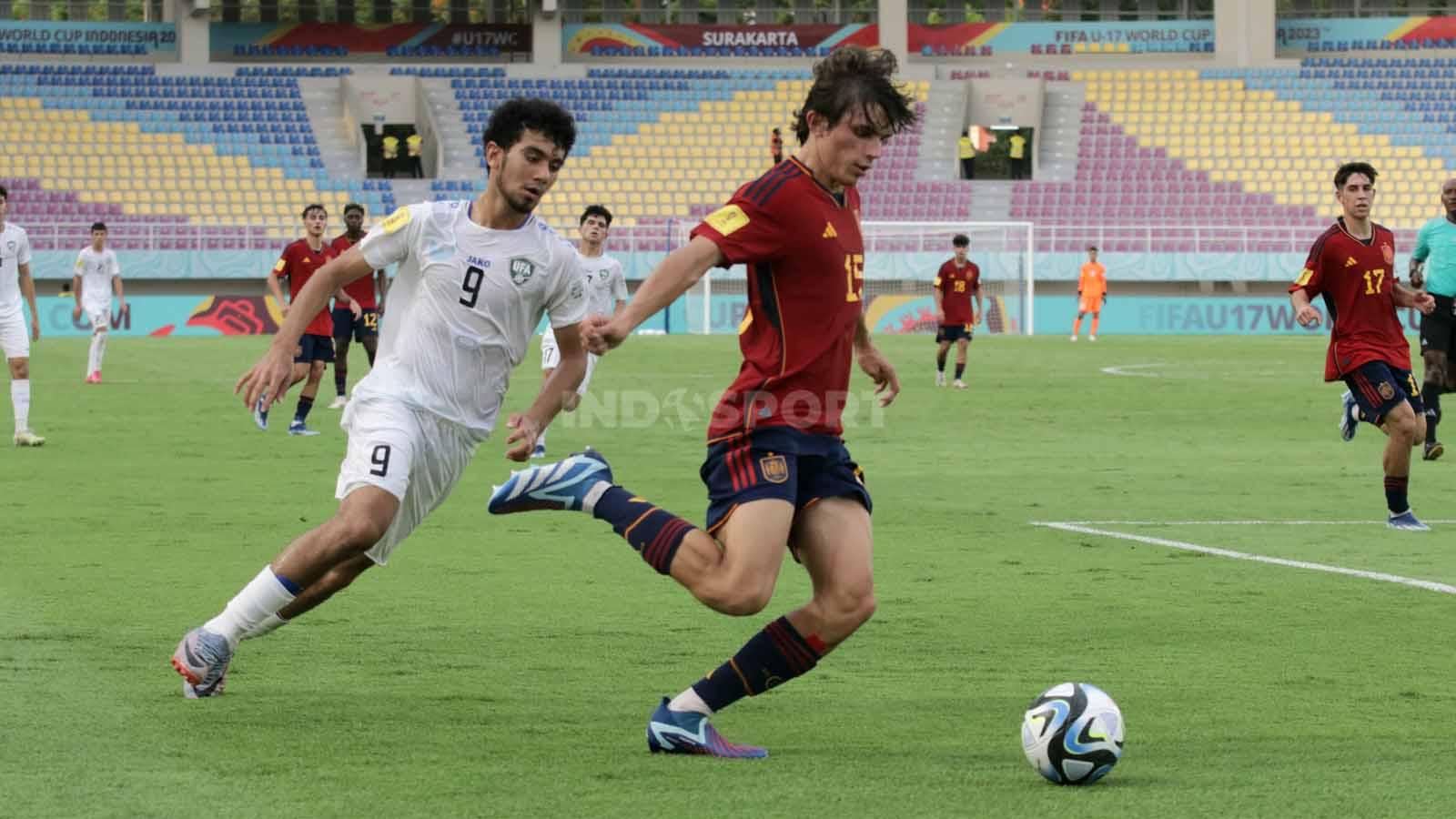 Aksi bek Spanyol, Andres Cuenca, menghentikan penyerang Uzbekistan, Amirbek Saidov, dalam pertandingan fase grup B Piala Dunia U-17 2023 di Stadion Manahan Solo, Kamis (16/11/23). (Foto: Nofik Lukman Hakim/INDOSPORT)