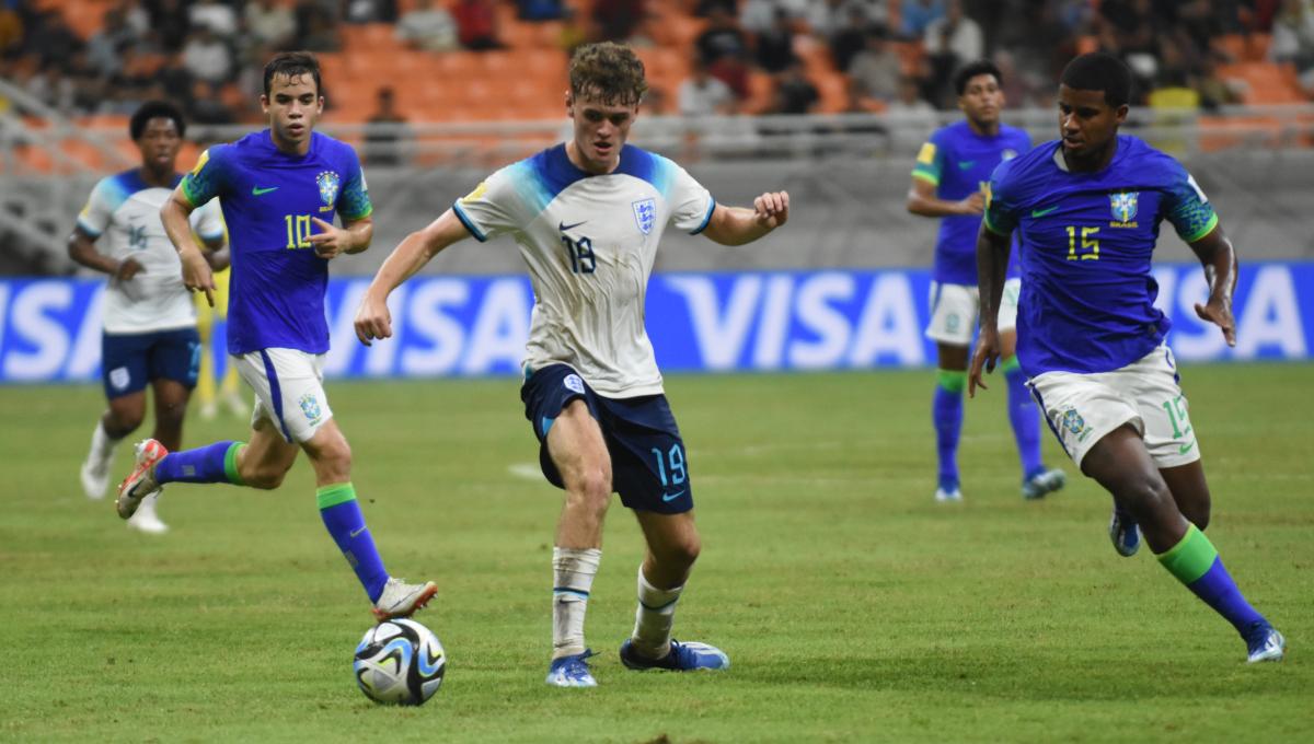 Pemain Inggris, Matty Warhurst mengamankan bola dari gangguan pemain Brasil pada laga ketiga fase grup C Piala Dunia U-17 2023 di Stadion JIS, Jumat (17/11/23).