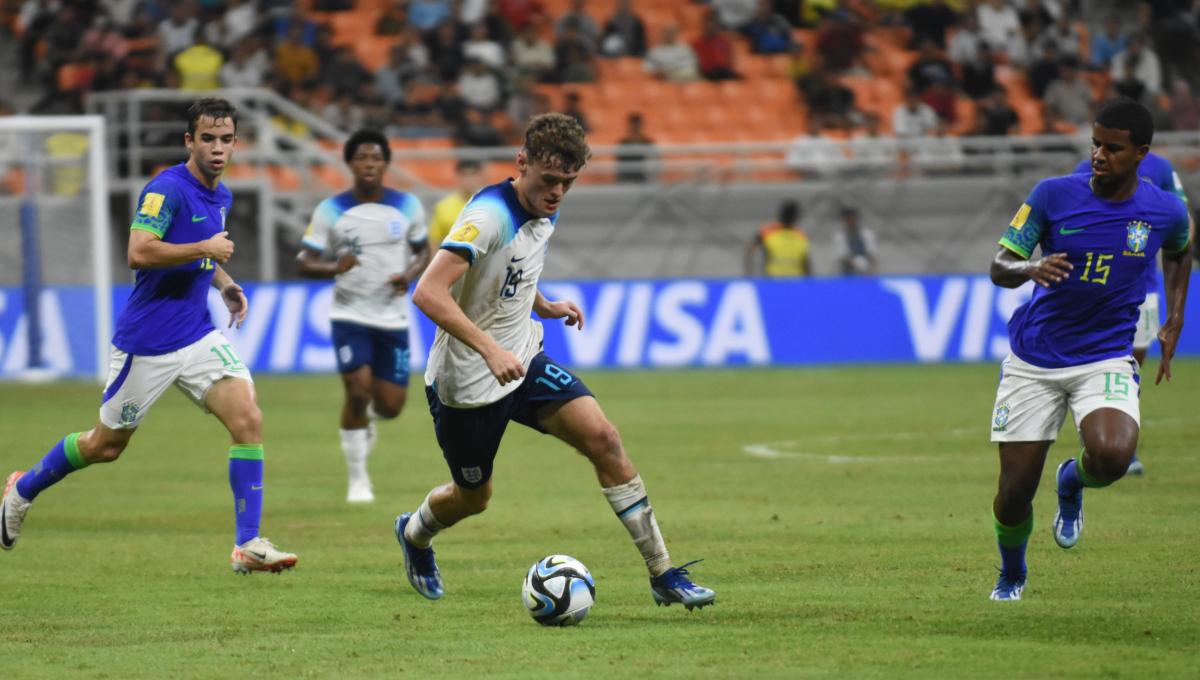 Pemain Inggris, Matty Warhurst mengamankan bola dari gangguan pemain Brasil pada laga ketiga fase grup C Piala Dunia U-17 2023 di Stadion JIS, Jumat (17/11/23).