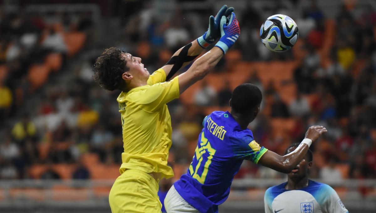 Kiper Inggris, Tommy Setford mencoba mengahalau bola yang mengarah ke gawangnya pada laga ketiga fase grup C Piala Dunia U-17 2023 melawan Brasil di Stadion JIS, Jumat (17/11/23).