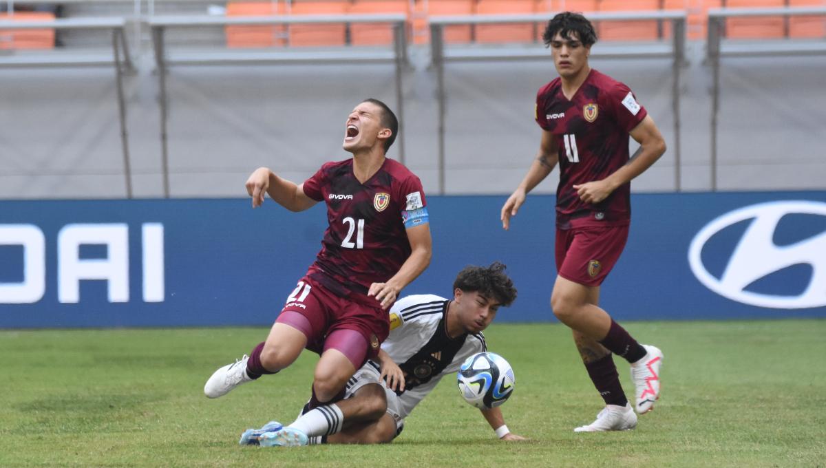 Pemain Jerman, Justin Von Der Hitz melakukan pelanggaran kepada pemain Venezuela, Nicola Profeta pada laga ketiga fase grup F Piala Dunia U-17 2023 di Stadion JIS, Sabtu (18/11/23).