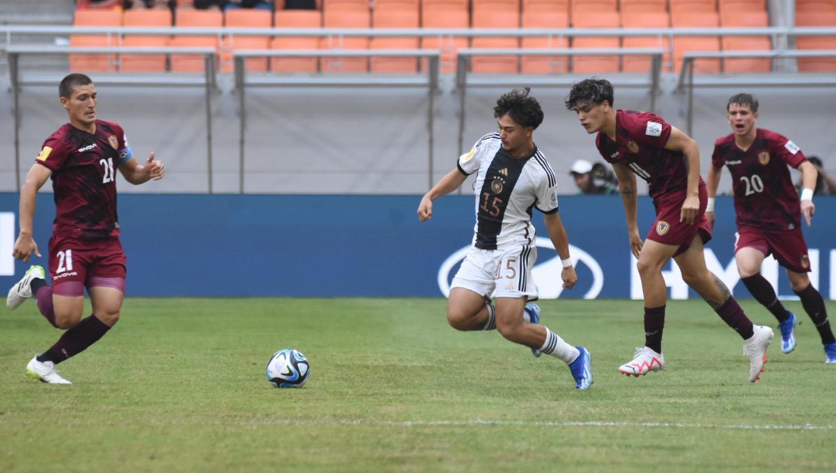 Pemain Jerman, Justin Von Der Hitz hendak merebut bola dari pemain Venezuela, Nicola Profeta pada laga ketiga fase grup F Piala Dunia U-17 2023 di Stadion JIS, Sabtu (18/11/23).