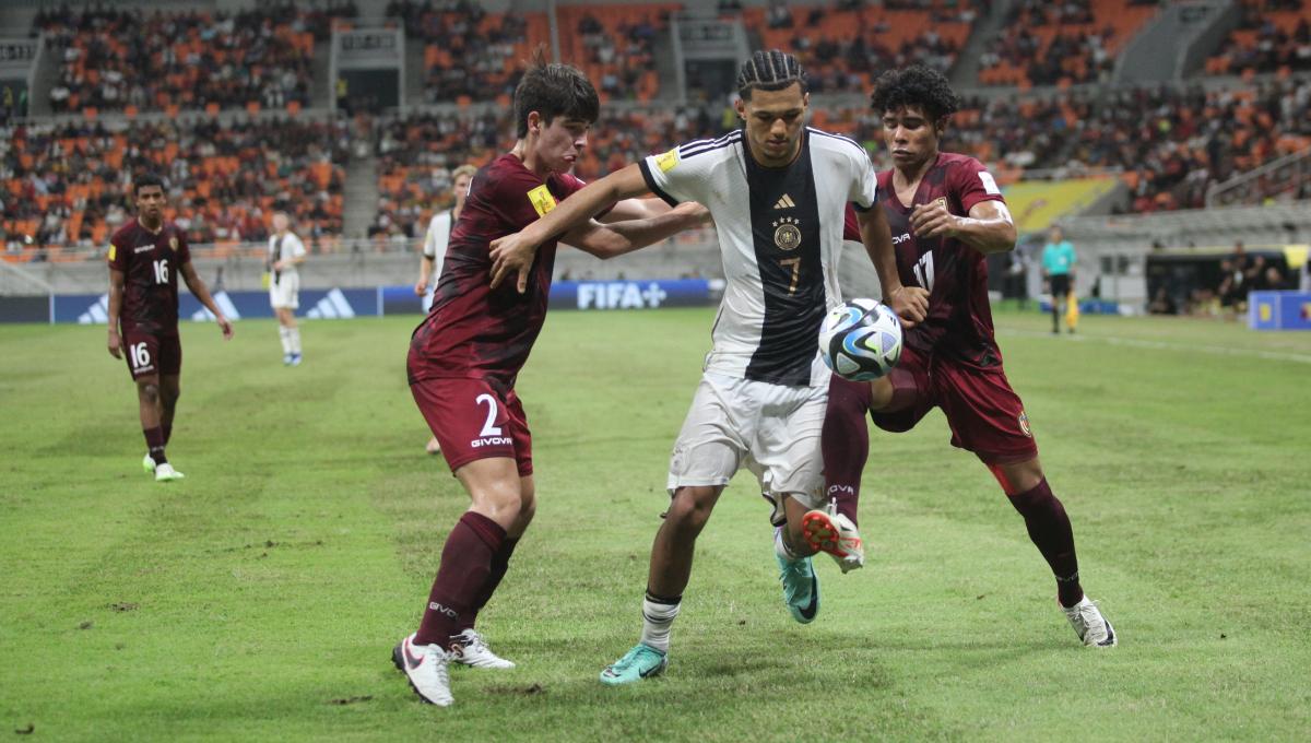 Pemain Jerman, Paris Brunner dijaga ketat dua pemain Venezuela pada laga ketiga fase grup F Piala Dunia U-17 2023 di Stadion JIS, Sabtu (18/11/23).