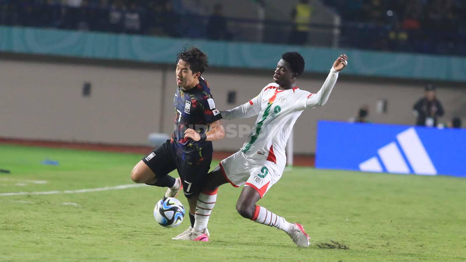 Striker Burkina Faso U-17, Diarra Jack menjegal pemain Korea Selatan U-17, Yoon Doyong pada pertandingan terakhir Grup E Piala Dunia U-17 2023 di Stadion Si Jalak Harupat, Kabupaten Bandung, Sabtu (18/11/23). Arif Rahman/INDOSPORT