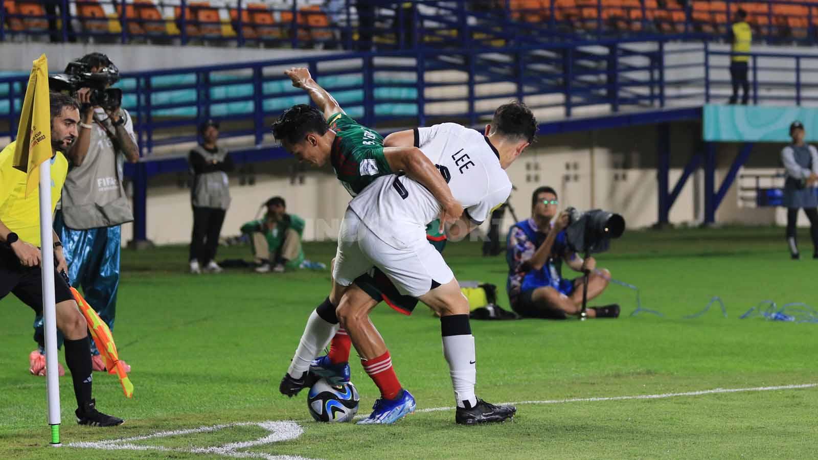 Stiker Timnas Meksiko U-17, Brandon Lomeli berebut bola dengan bek Selandia Baru U-17, Lee Ryan pada pertandingan Grup F Piala Dunia U-17 2023 di Stadion Si Jalak Harupat, Kabupaten Bandung, Sabtu (18/11/23). Arif Rahman/INDOSPORT