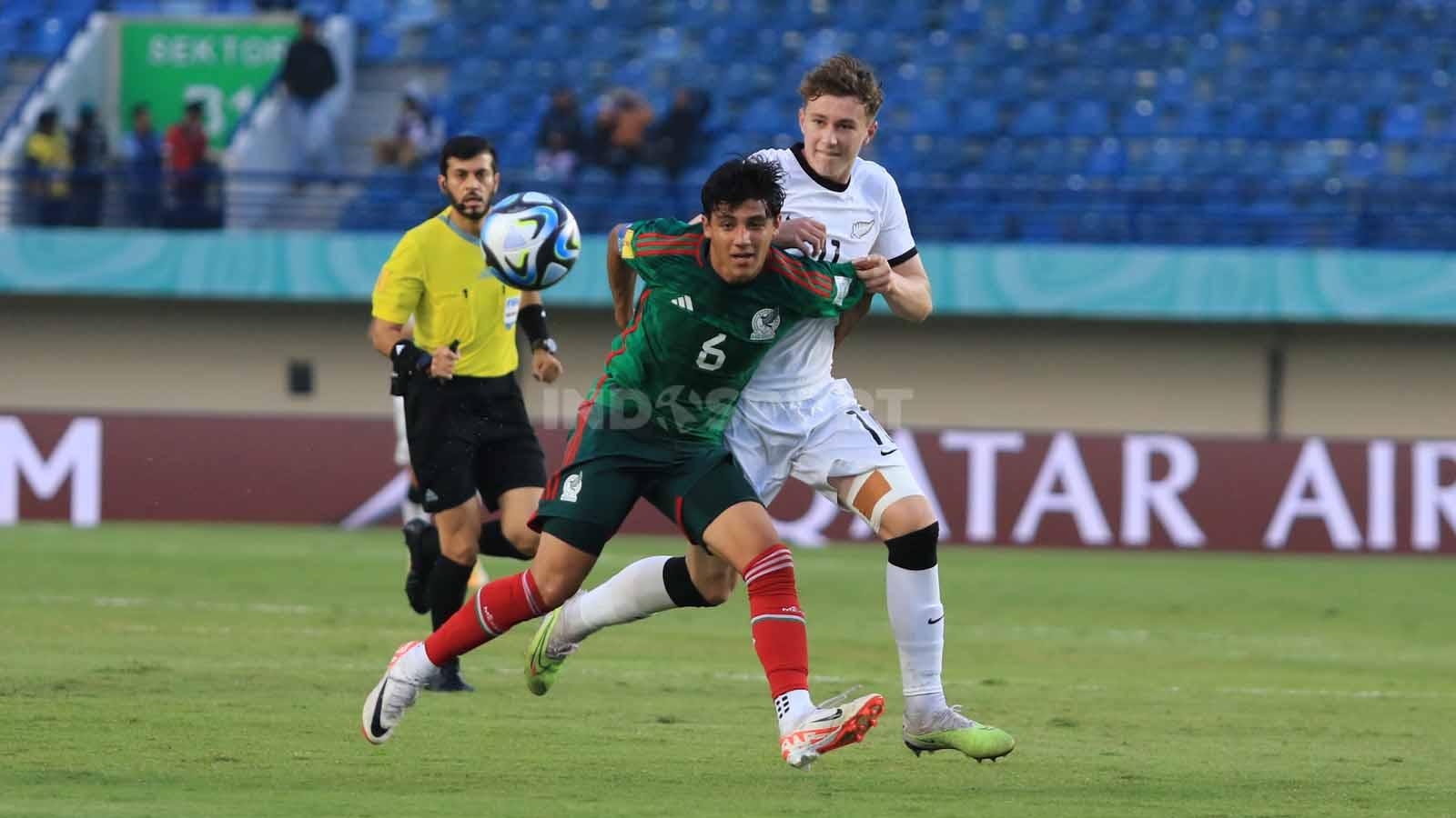 Gelandang Timnas Mexico U-17, Martinez Isaac mengawal ketat striker Selandia Baru U-17, Supyk Luke pada pertandingan Grup F Piala Dunia U-17 2023 di Stadion Si Jalak Harupat, Kabupaten Bandung, Sabtu (18/11/23). Arif Rahman/INDOSPORT