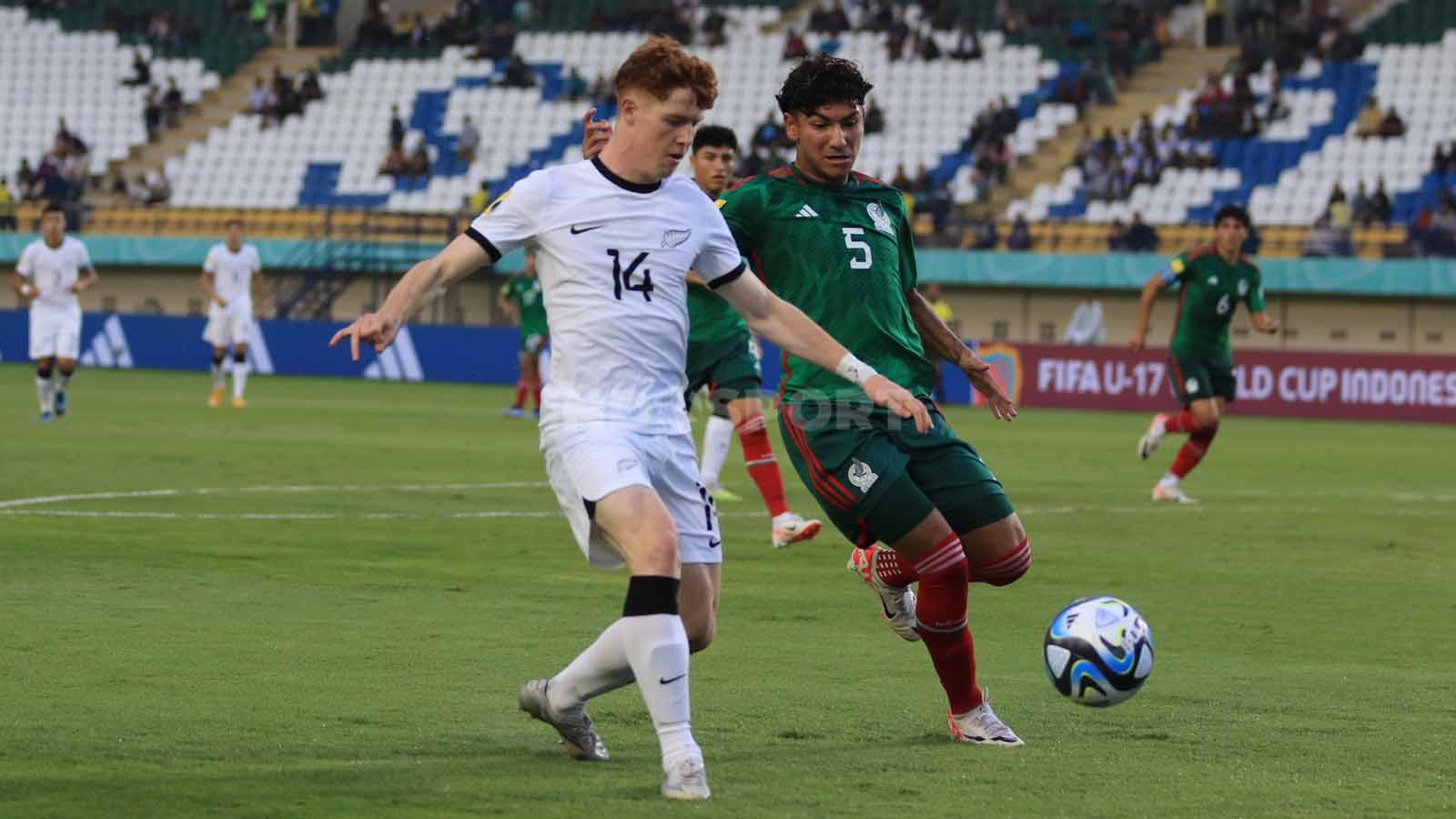 Bek Timnas Meksiko U-17, Romeo Javen mengawal ketat pemain Selandia Baru U-17, Murphy Nicolas, pada pertandingan Grup F Piala Dunia U-17 2023 di Stadion Si Jalak Harupat, Kabupaten Bandung, Sabtu (18/11/23). Arif Rahman/INDOSPORT