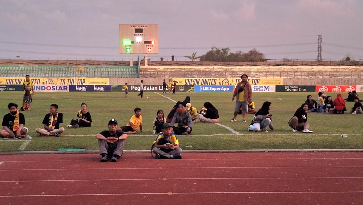 Suporter yg diarahkan ke dalam lapangan menhghindari kericuhan. (Foto: Ian Setiawan/INDOSPORT)