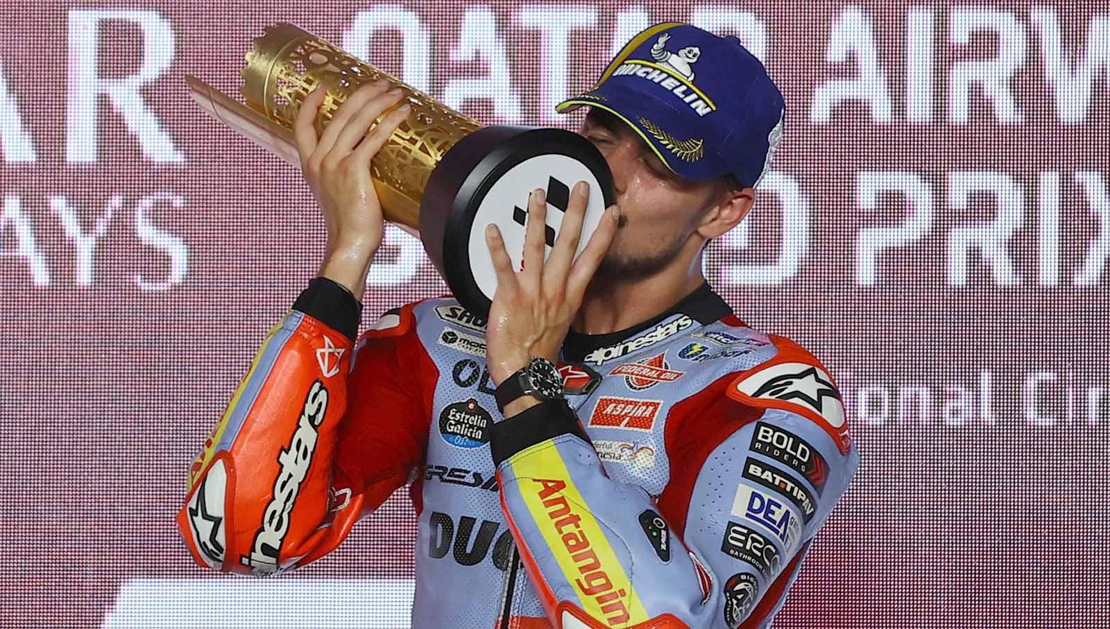 Selebrasi Fabio Di Giannantonio saat mengangkat dan mencium trofi di podium usai memenangkan balapan MotoGP Qatar 2023 di Sirkuit Internasional Lusail, Lusail, Qatar, Minggu (19/11/23). (Foto: REUTERS/Ibraheem Al Omari) - INDOSPORT