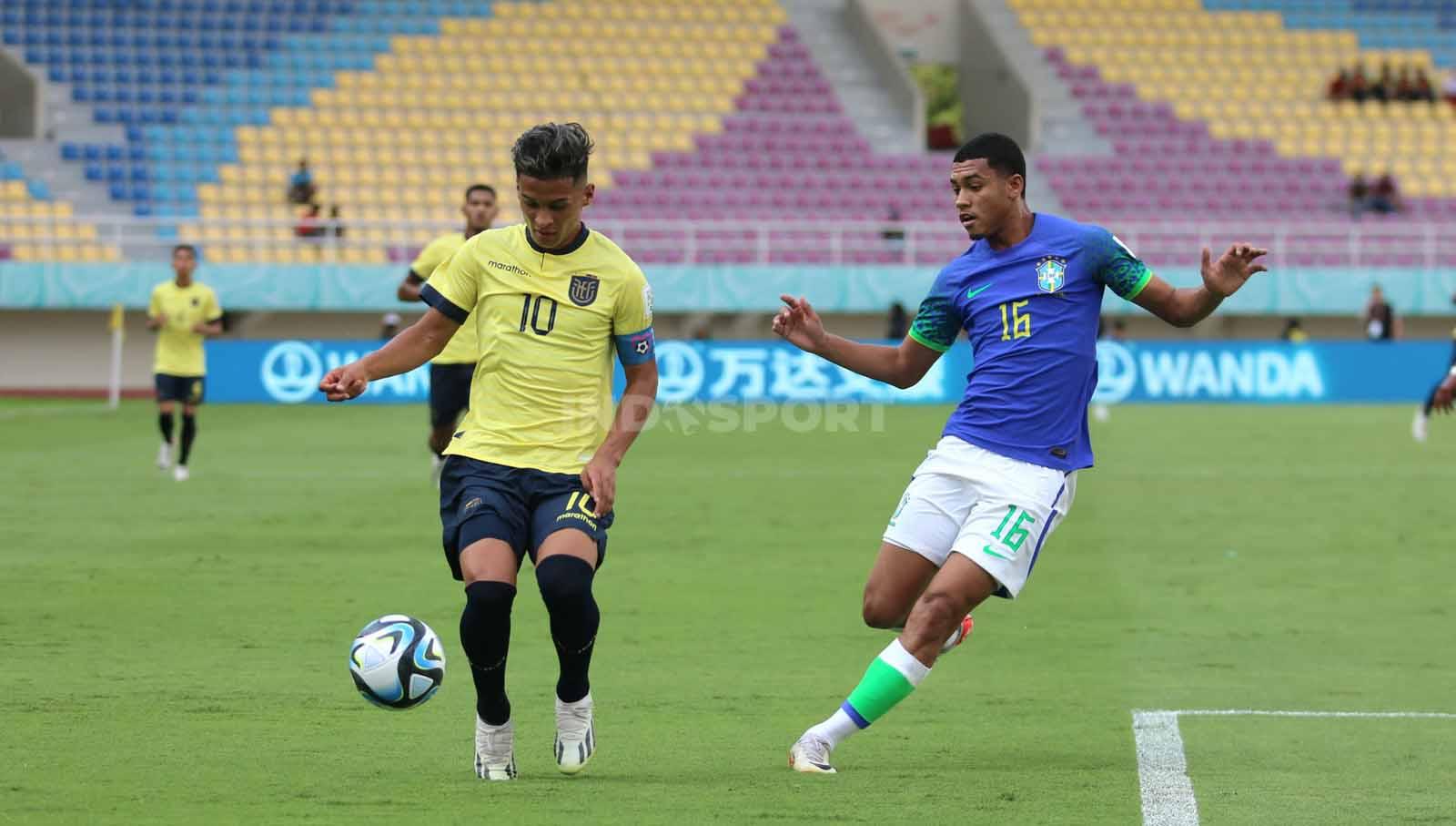 Gelandang Brasil, Jowo Henrique, mengawal pergerakan penyerang Ekuador, Michael Bermudez, dalam pertandingan babak 16 besar Piala Dunia U-17 2023 di Stadion Manahan Solo, Senin (20/11/23). (Foto: Nofik Lukman Hakim/INDOSPORT)