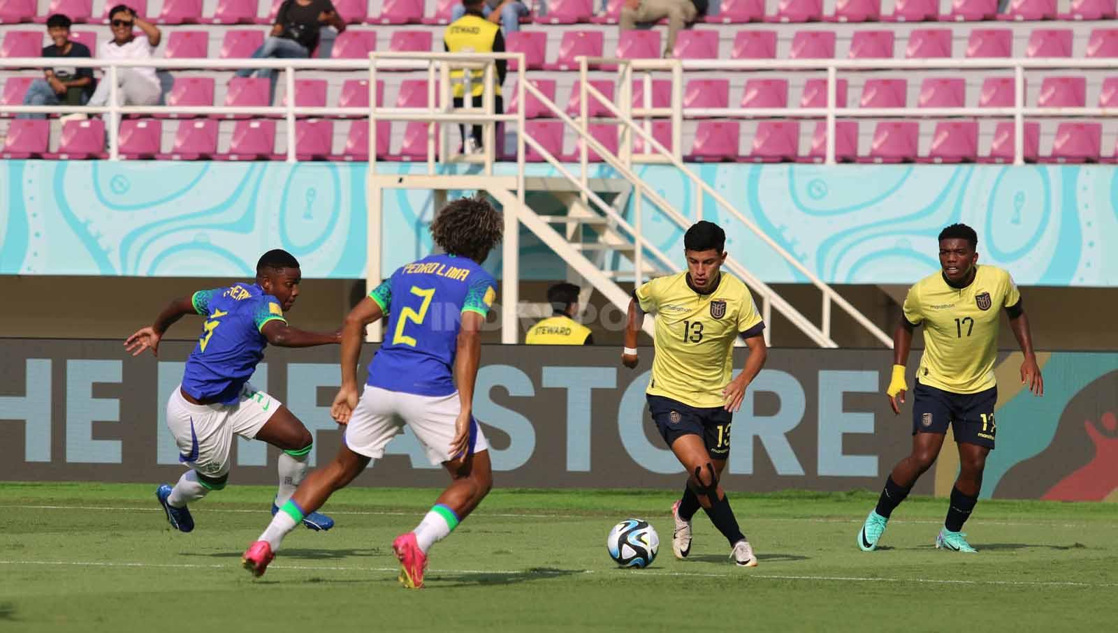 Gelandang Ekuador, Rooney Troya, berusaha melewati bek Brasil, Pedro Lima, dalam pertandingan babak 16 besar Piala Dunia U-17 2023 di Stadion Manahan Solo, Senin (20/11/23). (Foto: Nofik Lukman Hakim/INDOSPORT)