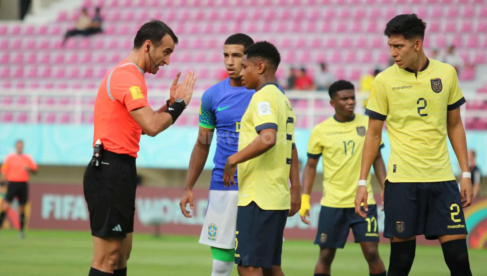 Wasit asal Turki, Atilla Karaoglan, saat berdiskusi dengan para pemain Ekuador dan Brasil dalam pertandingan babak 16 besar Piala Dunia U-17 2023 di Stadion Manahan Solo, Senin (20/11/23). (Foto: Nofik Lukman Hakim/INDOSPORT)