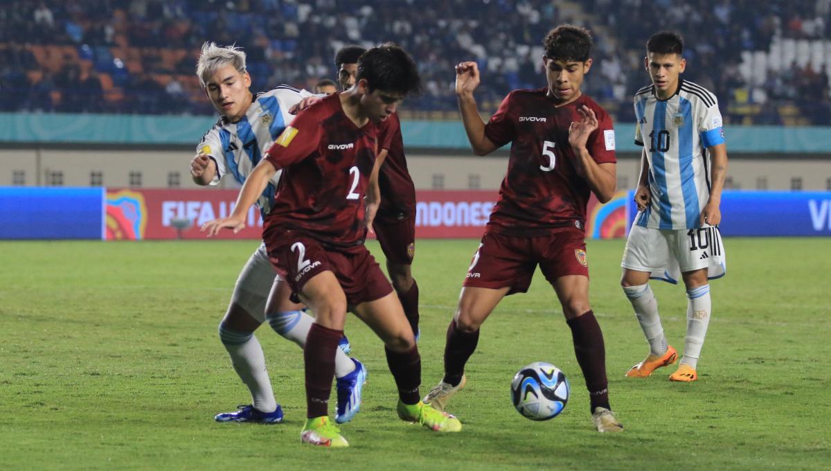 Striker Timnas Argentina U-17, Subiabre Ian dikawal ketat pemain Timnas Venezuela U-17, Ibbara Pablo dan Correa Jose pada babak 16 besar Piala Dunia U-17 2023 di Stadion Si Jalak Harupat, Kabupaten Bandung, Selasa (21/11/23). (Arif)