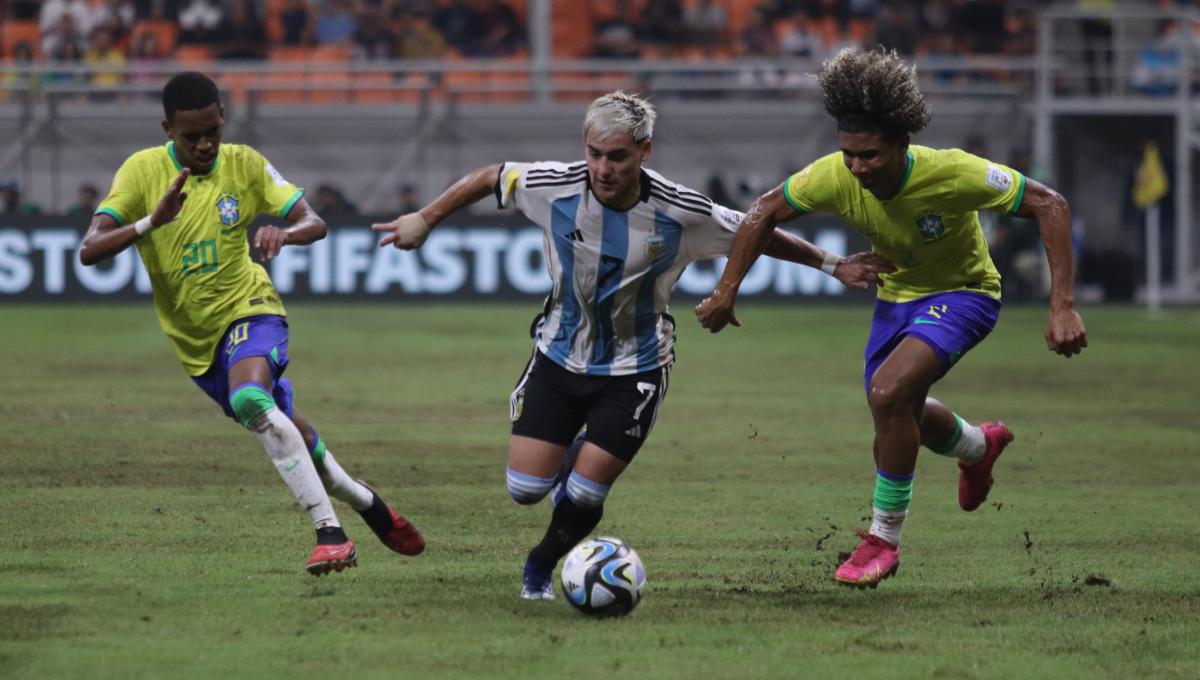 Pemain Argentina, Ian Subiabre melepaskan diri dan melewati penjagaan dua pemain Brasil pada laga babak 8 besar Piala Dunia U-17 2023 di Stadion JIS, Jumat (24/11/23).