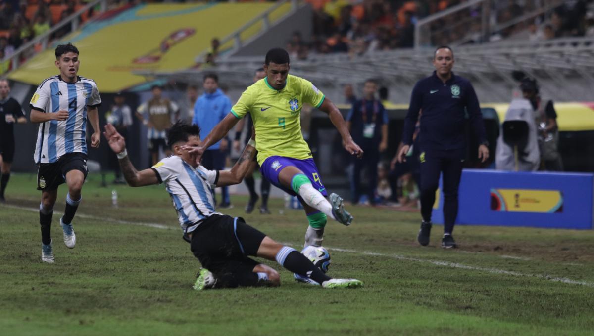 Pemain Argentina melakukan sliding tackle ke arah pemain Brasil pada laga laga 8 besar Piala Dunia U-17 2023 di Stadion JIS, Jumat (24/11/23).