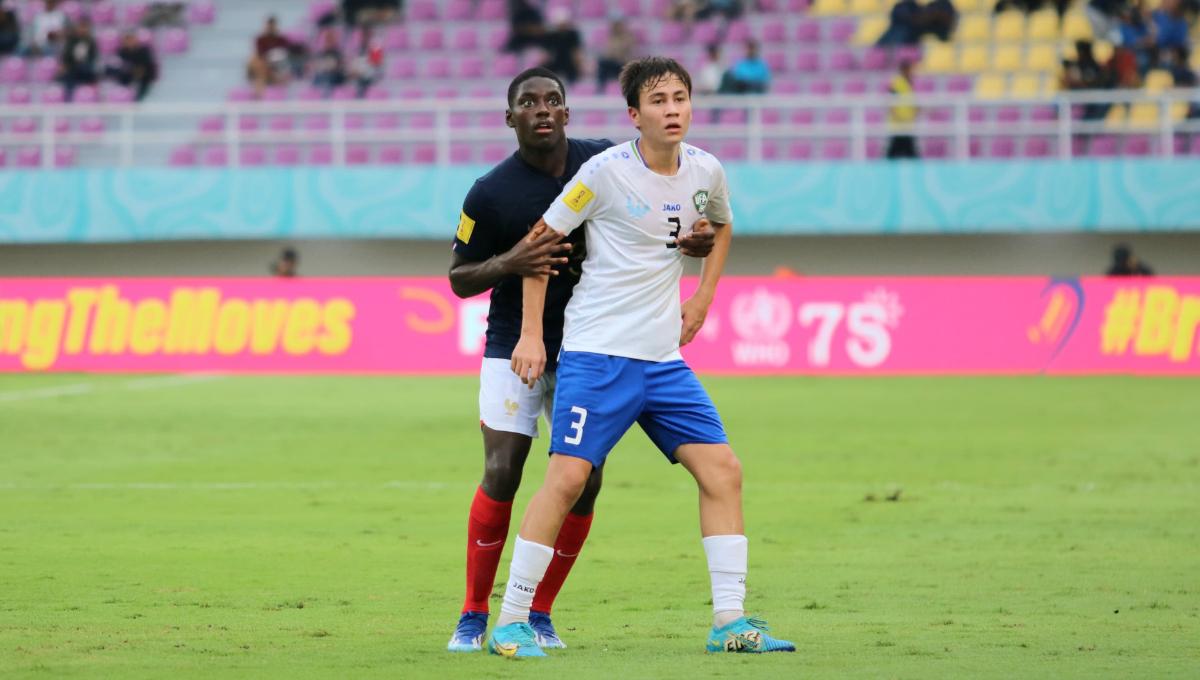 Bek Perancis, Nhoa Sangui, menjaga ketat bek Uzbekistan, Yakhyo Urinboev, dalam pertandingan babak 8 besar Piala Dunia U-17 2023 di Stadion Manahan Solo, Sabtu (25/11/23). Foto: Nofik Lukman Hakim