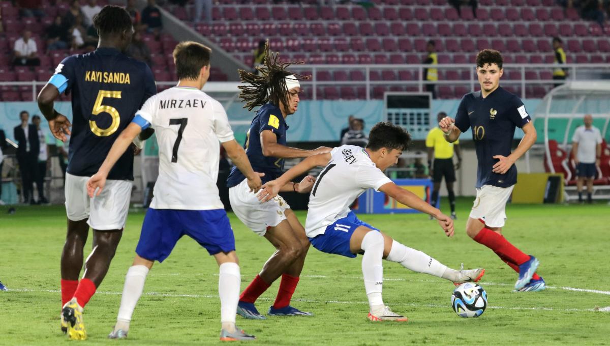 Gelandang Perancis, Mathis Amougou, mengawal ketat gelandang Uzbekistan, Kuvonchbek Abraev, dalam pertandingan babak 8 besar Piala Dunia U-17 2023 di Stadion Manahan Solo, Sabtu (25/11/23). Foto: Nofik Lukman Hakim