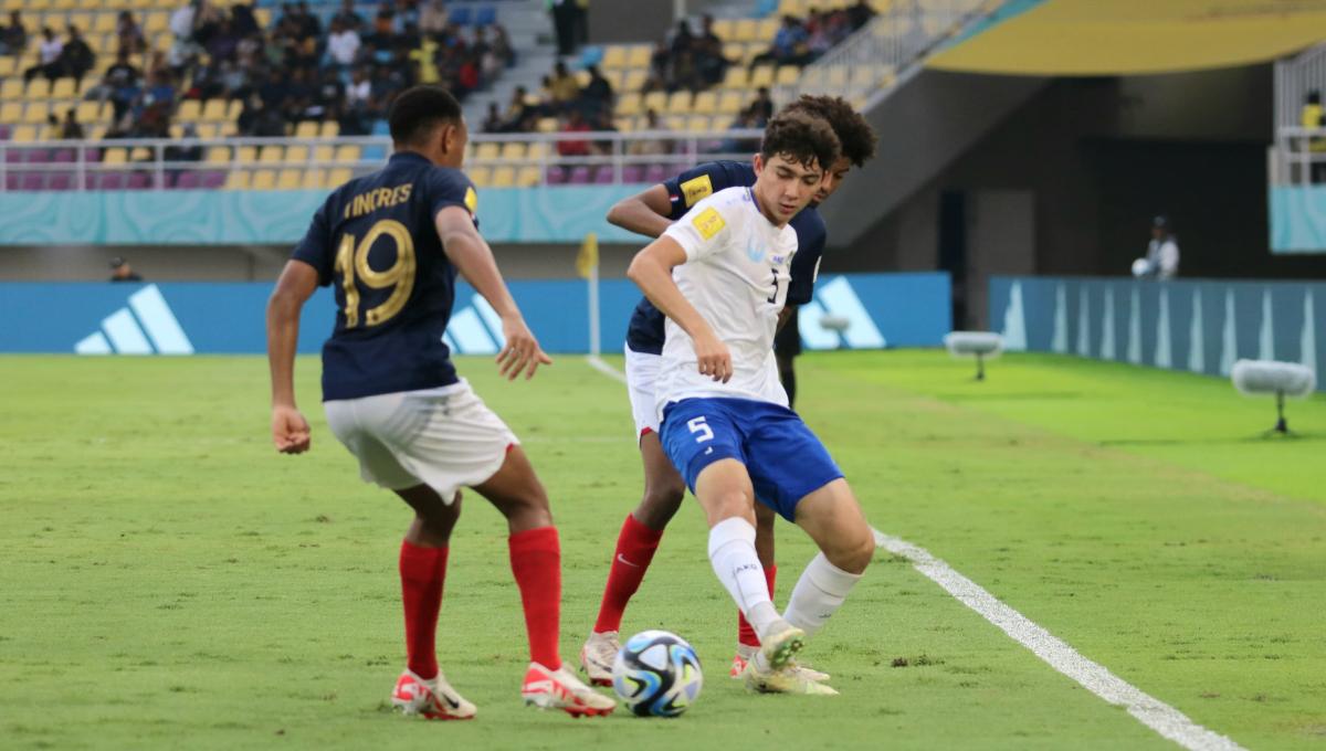 Bek Uzbekistan, Azizbek Tulkunbekov, saat melindungi bola dari kejaran bek Perancis dalam pertandingan babak 8 besar Piala Dunia U-17 2023 di Stadion Manahan Solo, Sabtu (25/11/23). Foto: Nofik Lukman Hakim